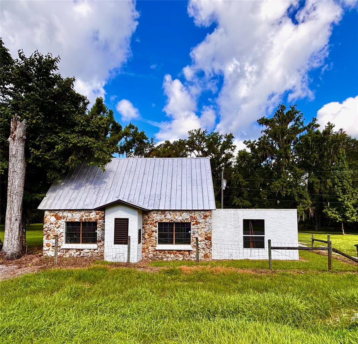 15.1 ACRES!! GREAT LOCATION!! Discover the possibilities with this unique 15.1-acre property offering the perfect blend of Old Florida charm, privacy, and development potential. Conveniently located off US 301 and only 8 minutes from I-75, this peaceful country setting is ideal for those looking for space and accessibility. The rustic, cabin-style home features 1,782 square feet with three bedrooms and one bathroom, and a metal roof.  Recent updates include a three-year-old air conditioning system and well pump, and the electric panel was replaced two years ago. Beyond the home, the property offers endless opportunities. A detached garage provides additional storage or workspace, while a second power pole and existing septic system, where a mobile home previously stood, make it easy to accommodate an RV, another mobile home, or future expansion. Zoned residential, this property is well suited for a variety of uses, whether you're looking to build your dream home, create a family compound, have a great shaded spot for horses or animals, or construct the workshop you've always wanted. Nestled near the Withlacoochee River, the setting offers a quiet, peaceful atmosphere and NO FLOOD INSURANCE IS REQUIRED (flood zone X). Whether you're a truck driver looking for a convenient home base with plenty of room for equipment, an investor seeking development potential, or someone dreaming of wide-open spaces to call your own, this one-of-a-kind property is ready to bring your vision to life. Schedule your showing today! Weekend showings only with appointment.