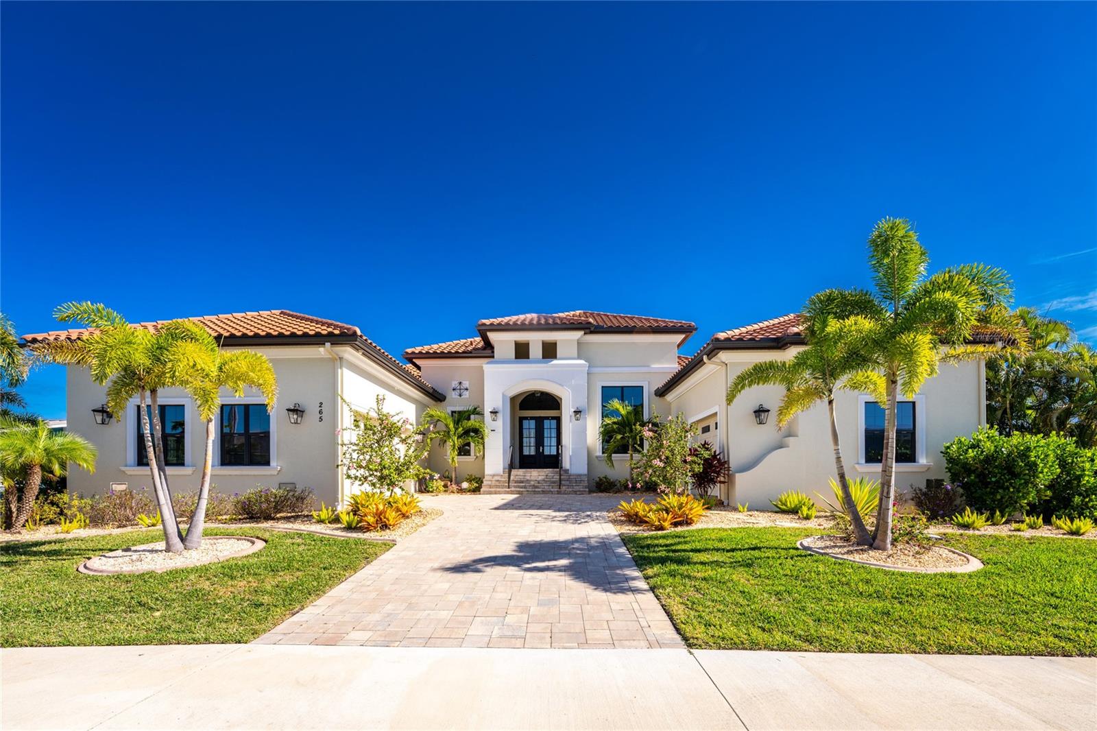 Welcome to 265 Severin Rd, Port Charlotte, FL 33982, an exquisite waterfront residence offering unparalleled luxury and sophisticated living. This highly customized AR Homes Veracruz model, spanning 4208 Sq Ft, presents 4 bedrooms and 4.5 bathrooms, meticulously designed to cater to the most discerning homeowner. Nestled on an oversized 15,000 sq. ft. lot, this property boasts 100 ft of seawall, providing an outstanding easterly view down the canal. Boating enthusiasts will appreciate the large covered dock with a 12K lift, offering less than 5-minute access to Charlotte Harbor. Step inside to discover a home where every detail has been thoughtfully curated. The gourmet kitchen is a chef's dream, featuring a walk-in pantry, a Wolf 6-burner stove with double oven, Wolf range hood, and a GE Monogram 48" refrigerator. Custom LED lighting throughout the home enhances the ambiance, while DC ceiling fans ensure energy efficiency. The Great Room, complete with a gas fireplace, and the Lanai are equipped with a Sonos Soundsystem, perfect for entertaining. The Bonus Room offers direct access to the lanai, a wet bar with a wine cooler, and a separate glass-enclosed wine room, creating an ideal space for relaxation or hosting guests. The primary suite is a sanctuary, featuring two large walk-in closets and a luxurious primary bath with dual vanities, a dressing table, two on-demand gas water heaters(one dedicated to the primary bath), and a walk-in shower with multiple shower heads and Moen digital controls. Outdoor living is redefined with a heated, saltwater pool and spa, complete with full automation and lighting. The expansive Lanai includes a full outdoor kitchen and a gas fireplace, promising unforgettable gatherings. For peace of mind, a 22kw whole-house generator and an alarm system with NVR are installed. The split 3-car garage features epoxy floors and upgraded side-lift openers with battery backup. Beyond the property, enjoy the convenience of a15-minute drive to historic downtown Punta  Gorda, offering exceptional restaurants, boutique shops, and weekly farmer's markets. Gulf beaches are just 25 minutes away. This residence is more than a home; it’s a lifestyle. We invite you to experience the grandeur and bespoke craftsmanship of 265 Severin Rd.  All dimensions and specifications are deemed to be accurate and should be verified to the buyer or buyer's agent's satisfaction.