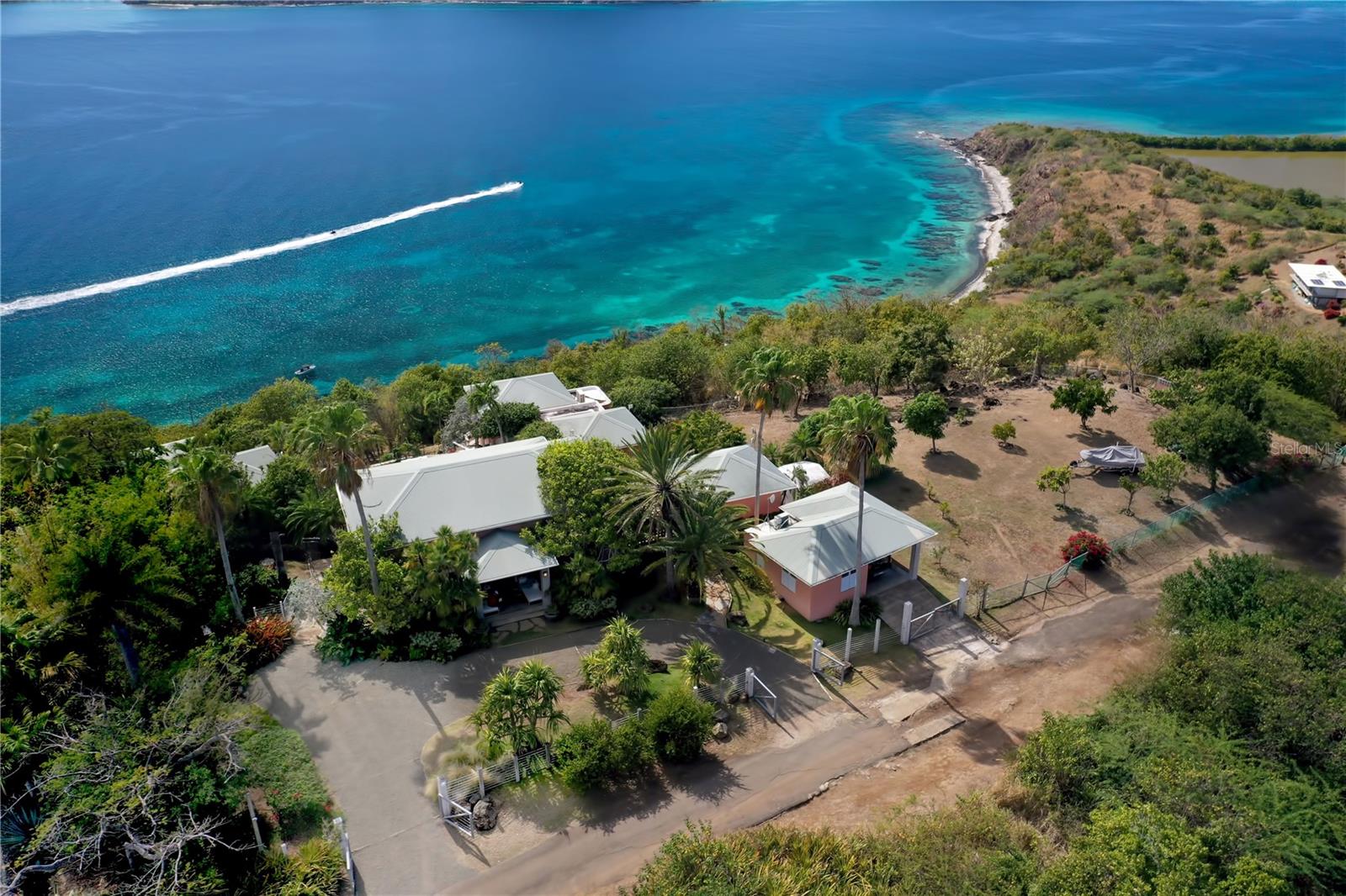 Perched atop a hill overlooking the Caribbean Sea in enchanting Culebra Island, this five-bedroom beautifully landscaped compound of nearly 2 acres, offers picturesque views of a stunning seascape, dotted with neighboring keys.

Consisting of five cottages spanning approximately 3,221 square feet, this private residence emanates comfort and ease in a peaceful and tranquil environment. The heart of the home is the primary bungalow.  It encompasses an elegant spacious great room with voluminous wood-beamed cathedral ceiling that reinforces the warm atmosphere, fully equipped kitchen, and light-filled living and dining room that flow to an exterior terrace overlooking the pool, sundeck, and to the expansive outdoor living areas showcasing panoramic views of Cayo Luis Peña.

Designed by renowned architect Pedro Rodriguez Flores, the four adjacent casitas are accessed by stone staircases and pathways and include independent entrances that allow privacy. The interiors feature high quality materials and finishes throughout, en-suite bathrooms and balconies with spectacular ocean vistas. This private retreat offers generous accommodations for a large family, visiting friends, or can also be used as a vacation rental.

The great outdoors featuring open terraces and verdant patios embraced by nature’s vibrant hues, is great for entertainment, barbecuing and alfresco dining. It offers the perfect setting to enjoy glorious sunrises and breathtaking Caribbean sunsets.  Other amenities in this enclave include custom built-in grill, exterior lighting system, outdoor guest bath, full back up electric generator, water cistern, garage, laundry room, pantry, multiple storage closets.

This unique tropical estate surrounded by lush vegetation, sits in a 7,948 square meter double lot, providing privacy and tranquility, yet one of its finest features is its proximity to various pristine beaches where you can enjoy a wide range of aquatic sports and recreational activities, and the convenience of a 10-minutes’ drive to town, making it the perfect choice in Culebra.  

Culebra Island is located off the eastern coast of the mainland of Puerto Rico; it is accessed by boat, ferry and numerous daily flights from San Juan and Ceiba.