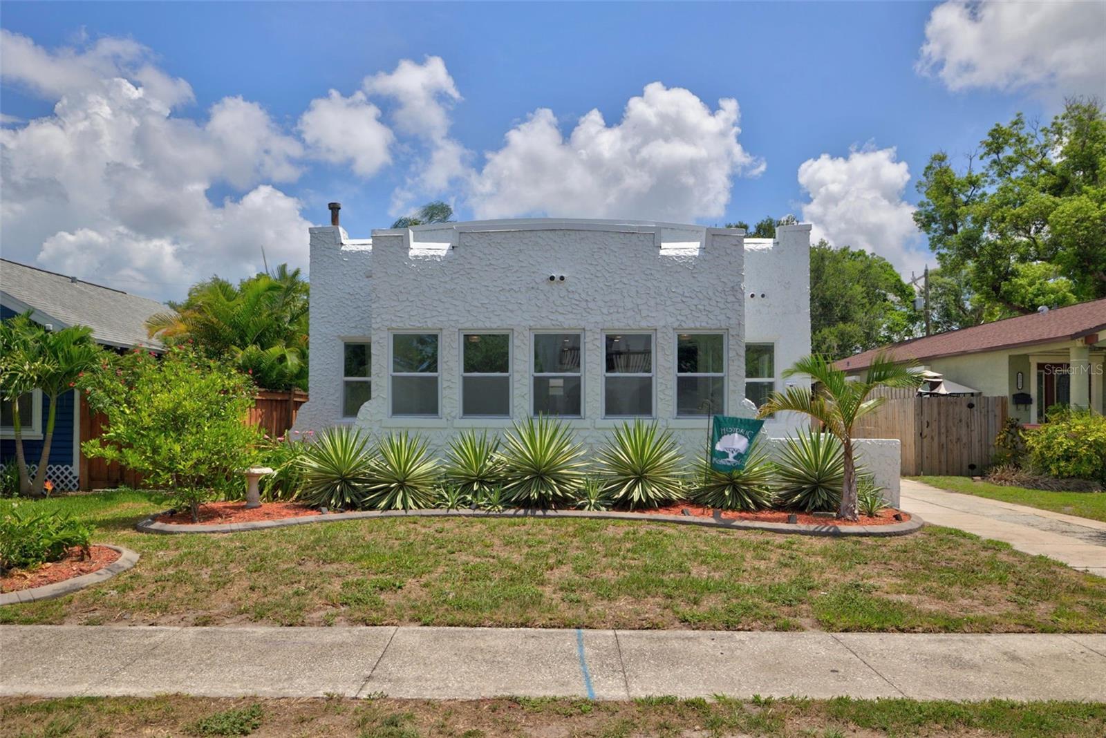 Welcome to this beautifully updated turn-key St. Petersburg property, where unique architectural character meets modern upgrades. This striking sun-drenched home immediately captivates with its Spanish-style crisp white exterior, brilliantly accented by a row of low-maintenance, tropical agave plants that perfectly frame the home. Plus, enjoy a rare off-street driveway leading directly to a detached garage that was fully renovated last year with structural improvements and a brand-new roof.

Inside, you are greeted by 9-foot ceilings and a seamless open-concept layout connecting the living room, dining room, sunroom, and kitchen into one expansive, sunlit space—perfect for entertaining. The completely remodeled kitchen serves as the home's anchor, boasting a large entertaining bar, premium stainless steel appliances including double ovens, a gas range and hood, abundant storage, and beautiful, muted multi-tonal luxury vinyl plank flooring throughout. Three bedrooms and two fully renovated bathrooms complete the interior layout, ensuring effortless comfort for guests and residents alike.

Peace of mind comes standard here, thanks to a major whole-home renovation completed roughly three years ago that included a new roof, a brand-new HVAC system, targeted foundation repairs, and a tankless water heater. Situated in the highly desirable, non-evacuation Flood Zone X neighborhood of Historic Kenwood. Located just blocks from vibrant downtown attractions, local dining, and the beach-bound SunRunner, this home offers an incredible lifestyle matched only by its welcoming community. As the seller fondly notes, "The porch parties here have a magical way of turning neighbors into lifelong friends." Schedule your showing today!