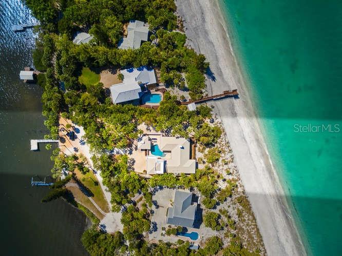Welcome to 776 North Manasota Key located in Englewood on southwest Florida’s 11 mile island just south of Venice in Sarasota County. Here you will experience the unhurried pace of life with Old Florida ambiance in this gated community, with fewer than 80 properties on the approximately 2-mile private road. This beachfront residence was completely gutted in 2018 and completed in 2020, with all new plumbing, electrical, new shell stone flooring, new appliances, impact doors and windows, and reconfigured to reflect a modern comfortable living space to enjoy for years to come. With 2,960 s.f. of living area, the house sits high on 1.3 acres with over 14 feet of elevation. The main Living area features an open floor plan with comfortable places to gather family and friends; informal dining with views to the gulf. The well designed kitchen is a cook’s dream with plenty of cabinetry and storage and views to the beautiful courtyard salt system pool. Privacy was a consideration in the space planning of the bedrooms: the primary suite encompasses the south wing of the ground floor, with the bedroom opening to a screened porch for relaxing and taking in the magnificent sunset views, while 2 ensuite bedrooms are on the north wing. Upstairs, a large bonus room can function in multiple ways; the large windows offer mesmerizing views of both the bay and gulf views from the access to exterior deck. Enjoy entertaining from the expansive gulf-side Ipe wood deck. Or escape to the beach through stepping stone pathways and choose your spot for taking in the magical sunset views. Here you can stroll the sandy beaches of your own secluded getaway with endless views of the gulf’s warm turquoise waters. Two outdoor showers allow ease of washing sandy toes. Enjoy beach combing for shark’s teeth, seashells and sand dollars or fishing and kayaking from your private dock. Unique to the island is the ability to join the Manasota Key Beach Club, located mid-key, with dining, tennis, pickleball, Bocci. Also convenient on the south end of the key are boutiques, waterside restaurants, water sport rentals for your enjoyment. Two bridges allow easy access to the mainland offerings with proximity to excellent schools, golf courses, restaurants. Paradise awaits you in this truly ready to move into beach home where you can relax and begin making lasting memories to cherish. Furnishings are optional under separate agreement.