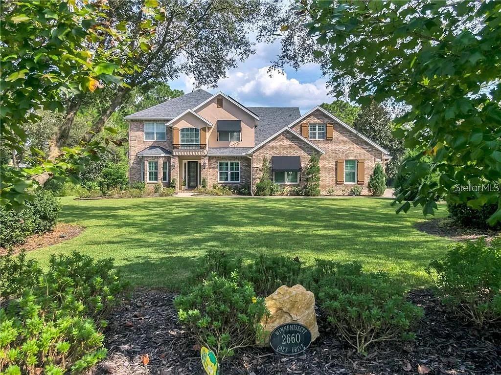 Welcome to 2660 Winnemissett Oaks Drive, an extraordinary custom estate in one of DeLand’s most exclusive communities. Located on a quiet, dead-end street in Winnemissett Oaks, this 6-bedroom, 5-bath executive pool home offers 4,814 sq. ft. of luxurious living space, a 3-car garage with over 1,100 sq. ft., and a long list of upgrades designed for comfort, performance, and lifestyle.Set on 2.5 meticulously landscaped acres, the home makes a striking first impression with mature landscape architecture, raised garden beds with irrigation, and a fully fenced backyard. Inside, soaring ceilings and a bright, open layout welcome you in. A formal dining room, spacious family room with gas fireplace and custom built-ins, and a chef’s kitchen flow seamlessly into one another, making everyday living and entertaining effortless.The kitchen is a true centerpiece—featuring marble countertops, high-end appliances, soft-close custom cabinetry, and an ice machine. The primary suite on the main floor is a serene retreat with dual walk-in closets, a spa-style bathroom with double walk-in shower and soaking tub, and peaceful views of the pool area. A second flex suite with its own full bath offers the perfect space for a home office, guest quarters, or private study. Upstairs, you’ll find four additional bedrooms and three bonus rooms—ideal for a gym, media room, rec space, or creative studio.Outdoor living is truly elevated with a screen-enclosed pool and spa, surrounded by a double-height pool cage, recently resurfaced deck (July 2025), and a gas-heated hot tub—perfect for relaxing evenings or entertaining guests.This home is as efficient as it is beautiful. A solar panel system generating approximately 24 megawatt-hours per year keeps energy costs down while supporting sustainable living. Additional features include a whole-home water filtration system, water softener, electric vehicle charging station, and coastal storm shutters for peace of mind.The oversized 3-car garage offers plenty of room for vehicles, toys, and projects, complete with a lighted workbench and custom tool storage. Located just minutes from I-4 and downtown DeLand, this property is tucked into a private neighborhood with a low HOA of just $1,100/year. With a perfect balance of style, space, and smart living, 2660 Winnemissett Oaks Drive is more than a home—it’s a lifestyle opportunity. Come see what makes this custom estate truly one of a kind. **MLS Info is intended to be correct but is not guaranteed and all information must be verified by buyers.**