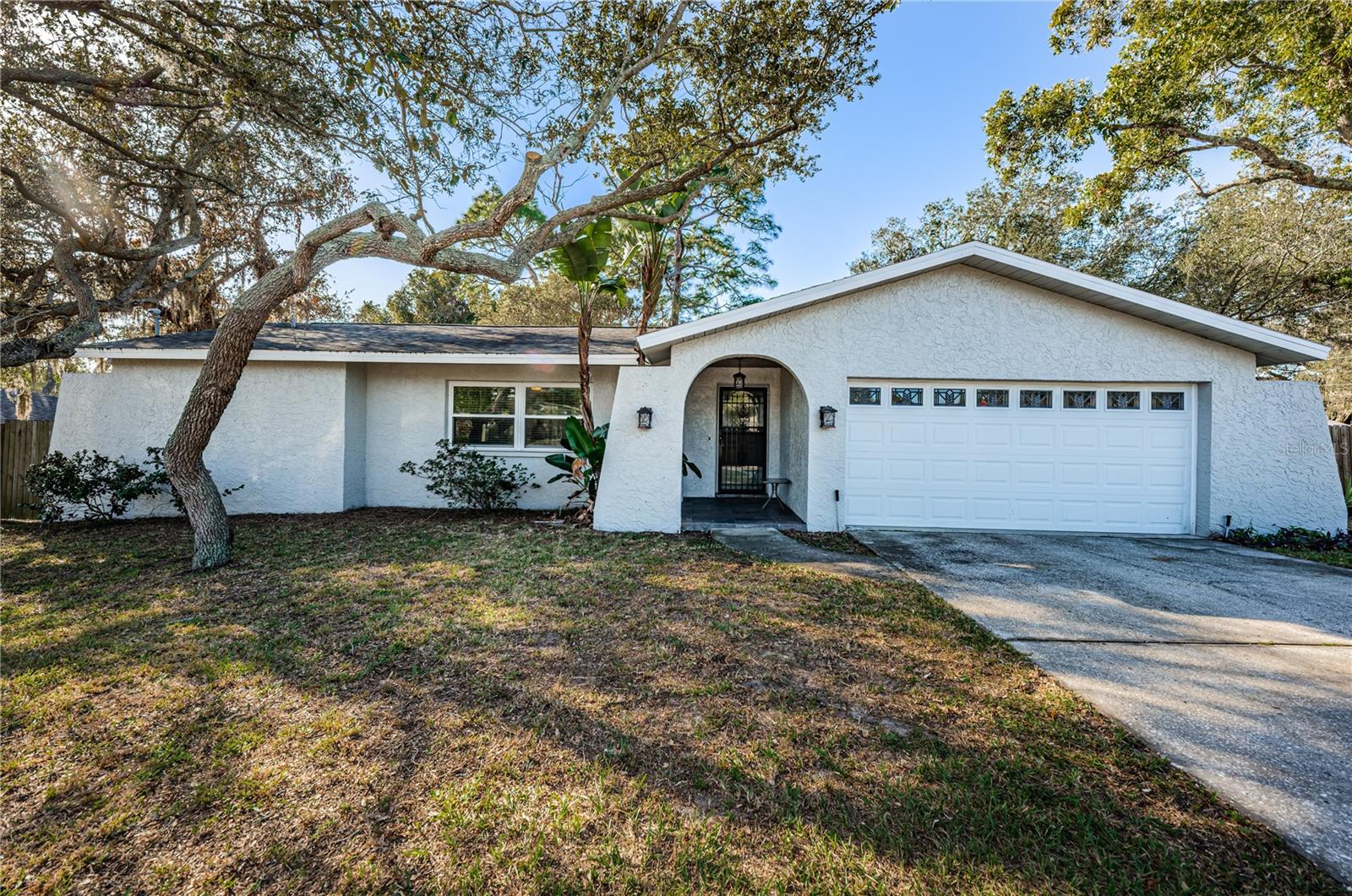 Absolutelly charming 2 bedroom, 2 bath home with attached 2-car garage in quiet established neighborhood minutes from historic downtown Tarpon Springs.  This home features a large remodeled gourmet custom kitchen with cherry wood cabinets and granite countertops open to sitting area with cozy wood burning fireplace.  Other upgrades include a BRAND NEW HVAC SYSTEM, newer double pane impact resistant windows and doors, garage door is hurricane rated, new tankless hot water heater, luxury vinyl plank floors everwhere except tile in baths, and the exterior has recently been painted.  NO HOA, NO FLOOD INSURANCE!! The large screened porch (could easily be converted to 3rd bedroom) overlooks a very private huge fenced backyard.  This home sits on a double (100 x 127) corner lot.  Enjoy the local culture of the famous Greek sponge docks, restaurants and shopping.  Close to Fred Howard Park, Anderson Park, Lake Tarpon and Sunset Beach.