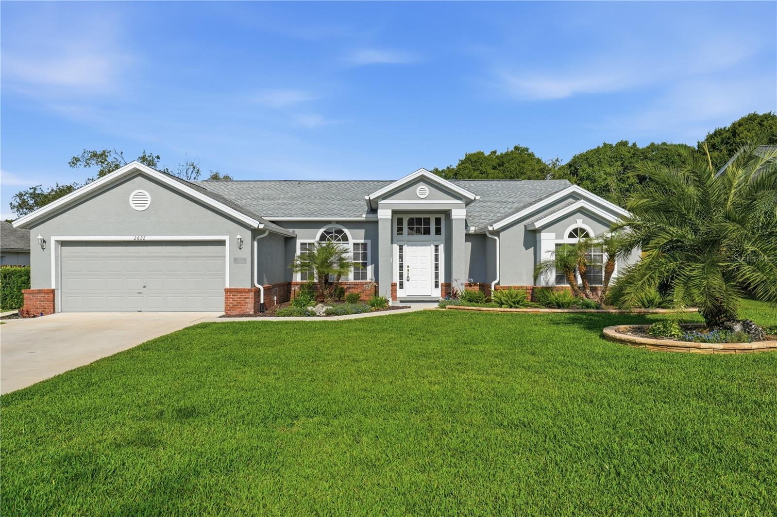 Welcome home to this beautifully renovated, 4-bedroom, 3-bath pool home nestled in a well-established and tranquil neighborhood filled with mature trees, friendly neighbors, and convenient access to every amenity. Dining, shopping, medical facilities, parks, lakes, and entertainment are all just minutes away, offering the perfect blend of comfort and convenience. Adding even more value and peace of mind, the home features a brand-new roof installed in 2026.

From the moment you arrive, you’ll appreciate the home’s inviting curb appeal. Mature palm trees frame the spacious front yard, while the attractive brick and stucco exterior, gabled roofline, and covered front entry create a warm and welcoming first impression. A long driveway and oversized 2-car garage provide ample parking, while the paved walkway leads guests to an elegant front entrance accented with sidelight and transom windows.

Step inside and discover a light-filled interior featuring vaulted ceilings, abundant natural light, and a spacious open floor plan designed for both everyday living and effortless entertaining. The tiled foyer opens into the formal living and dining areas, where French doors showcase beautiful views of the sparkling pool and provide seamless indoor-outdoor living.

At the heart of the home is the expansive open-concept kitchen and family room — the perfect gathering space for family and friends. The kitchen offers an abundance of wood cabinetry and countertop space, a breakfast bar, pantry, and a sunny dining nook. The adjoining family room features skylights, a cozy fireplace for cool evenings, and large sliding glass doors leading to the covered pool lanai.

The desirable split-bedroom floor plan provides privacy and flexibility for family and guests alike. The spacious owner’s suite features vaulted ceilings, a walk-in closet, and French doors opening directly to the lanai and pool area. The luxurious en-suite bath includes dual vanities, a relaxing garden tub, and a tiled walk-in shower.

Bedrooms two and three are generously sized and share a full hallway bath, while bedroom four and bath three are tucked away in a separate wing of the home with private lanai access — ideal for guests, in-laws, or a potential private suite setup.

Step outside to your own backyard retreat. The screen-enclosed pool and spa area offers abundant covered space for grilling, dining, and outdoor lounging, making it the perfect setting for summer gatherings and weekend relaxation. The fully fenced backyard provides plenty of room for guests and pets to play safely.