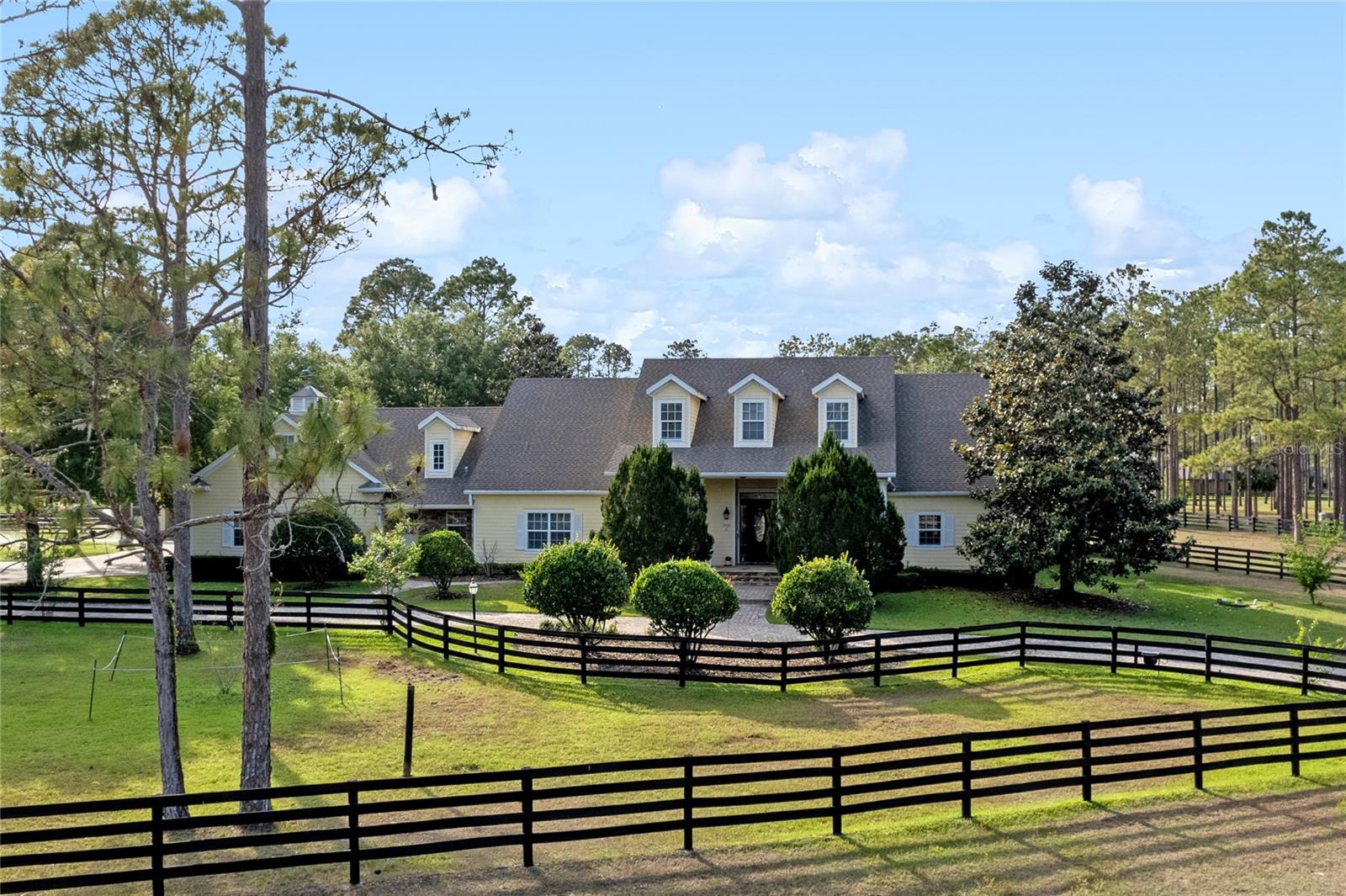 MAGNIFICENT COUNTRY STYLE HOME IN EUSTIS FLORIDA! Located in Lakewood Ranches Community. This beautiful 5 bedroom 5 bathroom home with 5,192 Sq. Ft of luxury living space is the perfect paradise for relaxation and tranquility,  Its gardens and the pool, the meadows and the horse area are unique. Sitting by the picturesque pool at sunset is an infusion of peace and joy for the soul. Its spacious rooms with high ceilings give the feeling of being outdoors. Walking around is a unique experience with nature. The mangers are equipped with air conditioning and their maintenance is simple. Getting up in the morning and going through fruit trees and gardens is a unique feeling. Also features a wet bar with gas grill, oversized gas fire pit. Climate controlled barn with tack room, indoor wash rack, 3 pastures, arena.  Master suite and Guest Suite located on first floor.  Master suite offers a sitting area overlooking pool area and pastures. Spacious Theater room/Bonus room features a wet bar with Refrigerator/ice maker, home office.  Call today to schedule your Private tour.