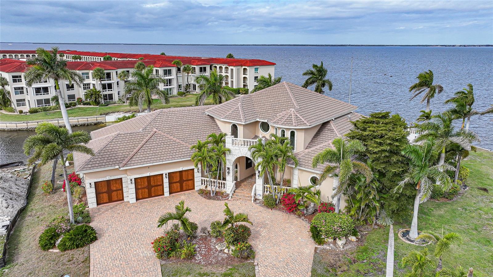 Simply one of the most impressive homes available in Punta Gorda. This harbor front, custom-built, two-story Towles home offers approx 240 feet of seawall, a 120-foot dock, and a 20,000-pound boat lift.
The expansive lanai and deck provide stunning, uninterrupted views of Charlotte Harbor and beyond, highlighted by a spectacular 50-foot infinity-edge pool with swim-up table and seating. No expense was spared in the construction of this exceptional residence.
Notable features include custom mahogany double front doors handcrafted in Honduras; concealed lanai power hurricane shutters; impact-resistant windows; and a fireplace constructed from Mediterranean-cut coral. A dramatic spiral staircase leads to a bridge accessing twin second-floor suites, each with private baths and walk-in closets. The second floor also offers a guest laundry, kitchenette, and a balcony that perfectly captures the Florida lifestyle.
The gourmet kitchen features abundant custom cherry cabinetry by Yoder Kitchen of Nappanee, Indiana (Amish-crafted), expansive granite countertops, double ovens with microwave and convection capabilities, two dishwashers, and a large warming drawer.
An incredible 1890s-style saloon provides a one-of-a-kind space for entertaining.
The home sustained damage during Hurricane Ian; approximately 95% of repairs have been completed, along with numerous upgrades. The property is being sold as-is, allowing the buyer the opportunity to add their own finishing touches.
A truly rare opportunity to own a landmark waterfront estate.  Lot 1 can be purchased with home.  Call for more information.