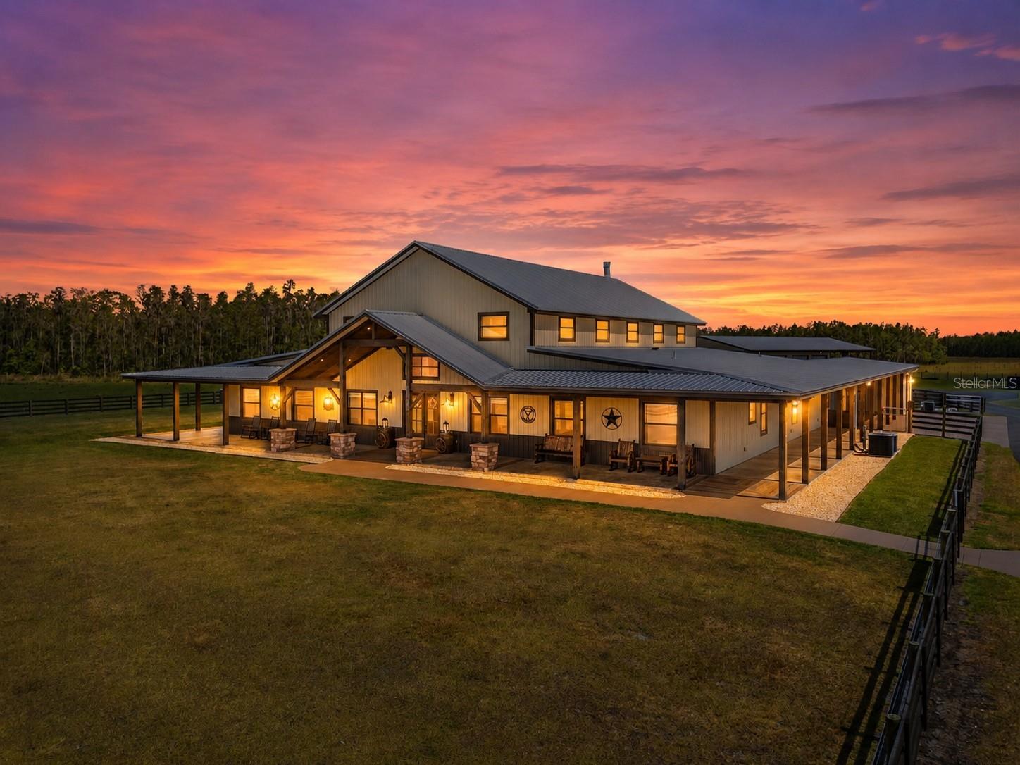 Welcome to Heaven on Earth - MULTI HOME-Family Compound in North Lakeland. Tucked away on over 100 acres of improved pasture, scattered cypress heads, and multiple ponds this extraordinary family compound offers a rare blend of rustic luxury, multi-generational living, and serene Florida countryside. Abundant with wildlife including deer, turkey, and cows, this one-of-a-kind estate is the perfect setting for those seeking space, privacy, and endless possibilities. The Main House 11657 Moore Rd. (2023): Reminiscent of a traditional Barndominium, the main residence is a custom-built masterpiece with nearly 12,000 sq ft under roof (approx. 7,000 sq ft of living space). Constructed with block and poured concrete, metal siding, and designed for longevity, comfort, and function — this home is both ADA-compliant and visually striking. Inside, soaring ceilings with exposed wooden beams, an expansive open-concept kitchen with high-end stainless appliances, and a massive walk-in pantry make everyday living and entertaining effortless. The large island is ideal for hosting those large gatherings or simply serving your Sunday morning breakfast. The home features 5 bedrooms and 4 bathrooms, including dual primary suites connected by a luxurious Jack-and-Jill bathroom with a soaking tub and oversized shower. Two additional guest suites have private en-suite baths. A spacious mudroom and bonus utility room for storage, workspace, or pet accommodations. The true star of the show is the stone wood burning fireplace located centrally in the grand sized family room. A detached 588 sq ft bonus room (ideal for a game room, gym, or office) connects via covered breezeway and oversized carport, perfect for ATVs or full-size vehicles. Outside is an entertainers dream, enjoy a resort-style screened heated pool and spa with beach entry, fountains and amazing light features. The details in the expansive wrap around porch are simply amazing. From stamped concrete to tongue-and-groove ceilings, stone work and beautiful beams it truly is breathtaking. For added comfort this home does feature a full-property industrial-grade generator capable of powering the home for up to two weeks. 2nd Home 11651 Moore Rd. (2019): Privately set along the asphalt drive, this custom-built 3 bedroom, 2.5 bathroom farmhouse-style residence offers nearly 3,000 sq ft of living space. Designed with both comfort and style in mind, it boasts an entertainer’s kitchen with granite countertops and a large central island, a generous den/playroom, and pool-access half bath. Outdoors features a sparkling pool and spa with travertine decking and fenced yard. Metal roof and large carport complete this charming yet modern home. Additional Living Spaces & Structures: Free-Standing Two-Story Apartment: Loft-style barndominium with 1 bedroom, 1 full bath, full kitchen, washer/dryer, upstairs loft, open carport, and screened lanai. Workshop #1: Enclosed space with side attached open pole barn — perfect for storing farm equipment.  Workshop #2 with Luxury Apartment attached: Large shop with pole barn area and a brand new luxury two-story apartment with 1 bedroom, 1 bath, full kitchen, and loft. This estate is zoned agricultural with potential for additional dwellings under the ag exemption. Whether you’re looking for a working ranch, multi-generational homestead, or event-friendly destination, this property is a true legacy compound. Parcel 24-26-21-000000-031010 included in listing price.