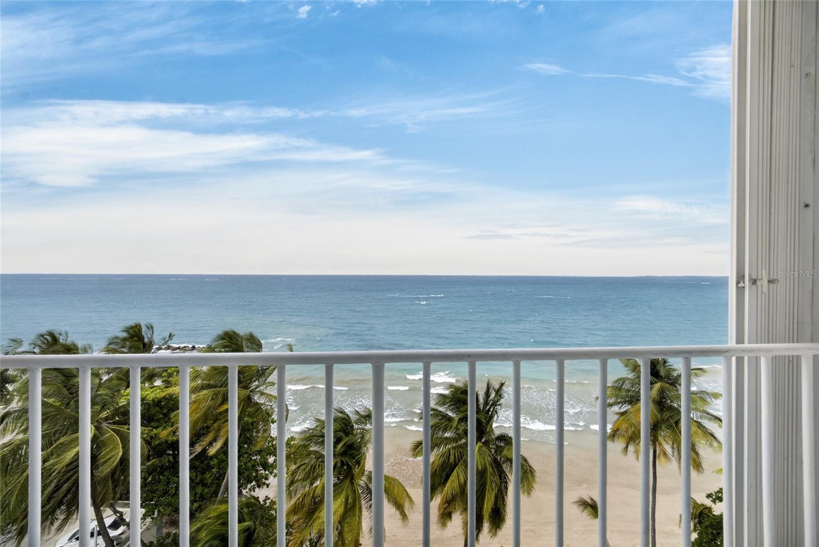 In the heart of Isla Verde, inside the Las Gaviotas building, sits an exceptional residence on the 7th floor with direct, unmatched views of the Atlantic — the kind of panorama you'd normally only take in from a cruise ship out at sea.

This is one of the few units in the building with the most sought-after layout: two bedrooms, two baths, and covered parking. And it isn't just the floor plan that sets it apart, but the level of full remodeling it has received, where every detail was thought through with intention and executed with top-tier materials.

From the moment you step through the door, the open concept flowing between kitchen, dining, living area, and balcony delivers the ocean head-on, without interruption. The original floors were removed and replaced with carefully selected terrazzo, in tones that evoke beach sand and keep the surface cool throughout the day. 

The kitchen, the true heart of the home, was designed and installed in PVC with a wood countertop and a backsplash that mirrors the movement of the sea. It comes equipped with high-end appliances from the Samsung Bespoke line, whose white glass finish resists oxidation while elevating the aesthetic of the space.

Structural safety was handled at the same level as the design. Every door and window is PVC — specialized work that only two companies on the island perform — installed to prevent corrosion, with glass rated to withstand winds of up to 160 miles per hour and complemented by storm panels for maximum protection. The interior gypsum board walls were replaced with a more durable material, resistant to moisture and mold, a detail that makes all the difference in a coastal climate.

Both bathrooms were fully remodeled, with floor-to-ceiling tile and highly curated, high-quality fixtures. The finishing touch came with a custom-built closet in the master bedroom, featuring an integrated shoe rack, drawers, organized spaces for your comfort, and new closet doors. The apartment also includes its own laundry area and is completely move-in ready.

The condominium offers direct beach access and, for the greater enjoyment and security of its owners, does not allow short-term rentals — real value for anyone seeking peace of mind and a stable community. The building is equipped with a water cistern serving the entire property and a power generator for common areas — practical peace of mind that matters in a coastal climate. Its location is among the most privileged in Isla Verde: away from the hustle, yet just 5 minutes from Luis Muñoz Marín International Airport.

Your next chapter begins here.