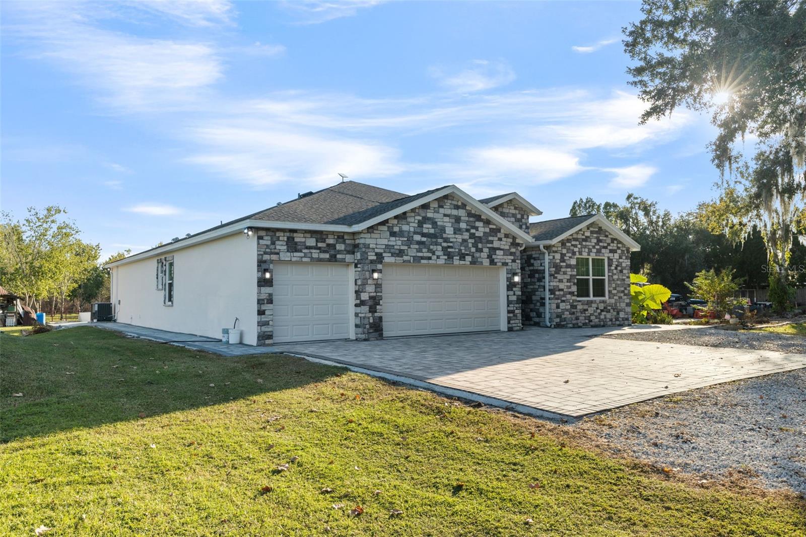 PRICE CORRECTION! Private land. Upgraded. Move-in ready with a barndominium in progress! You’ve just discovered a property so unique that you need to see it today. This modern, newer home sits on over 5 acres of private, tree lined land with 360-degree wooded views and no nearby neighbors. a rare combination of space, privacy, and style in the Plant City area. Unlike many large acreage properties that have dated homes or basic construction, this one is fully upgraded inside and out. From the moment you pull into your pavered driveway, you’ll notice the attention to detail: a complete elevation design, a 3 car garage with epoxy flake and clear-coat flooring, chainless direct-drive openers, and upgraded electric outlets. Step inside through the foyer with tall ceilings, crown molding, your first bedroom to the right. Continue to a spacious home office behind elegant French doors, perfect for remote work or a creative studio. Every bedroom in this home has access to its own bathroom and linen closet. In all, a thoughtful layout that adds both comfort and privacy. The great room and dining room form the heart of this home. With open space that can easily accommodate a 25 person dining table, it’s ideal for entertaining during the holidays. A dry bar with wine-fridge space enhances your hosting potential. The gourmet kitchen will impress even the pickiest chef. Featuring vaulted ceilings, custom solid wood shaker-style cabinetry, soft close doors, under cabinet lighting, a built-in spice rack and wine rack, and dark stainless-steel appliances under extended warranty, it’s a showpiece. The quartz-topped island includes a sink, dishwasher, recessed shaker panels, and electrical outlets making it as functional as it is beautiful. Adjacent to the kitchen, the living room offers a grand, open feel with tall ceilings, crown molding, a triple sliding glass door leading to the lanai. There’s more than enough room for your custom entertainment center and décor without sacrificing space. Your primary suite is a true retreat. It features vaulted ceilings, two large closets with built in cabinetry, and dual sliding doors that open to the lanai. The ensuite bathroom includes a soaking tub, walk-in shower with floor to ceiling tile, double sink and heated ambient lit mirror, and a private toilet area. Step out onto the lanai and enjoy panoramic views of your own farm setting. The home sits on a raised 36 inch foundation with brick detailing and pavered surroundings offering both beauty and practicality, with the potential to reduce property insurance premiums due to its elevated feature. This sale also includes the adjoining parcel 4819 Miley Road, which features its own electricity, well, and easement road for access to the rest of the land. A perfect blend of modern construction, premium upgrades, and rural tranquility minutes from major routes, dining, and Tampa access. tour today and experience what makes this one of the most desirable acreage homes in Plant City, FL (33565).