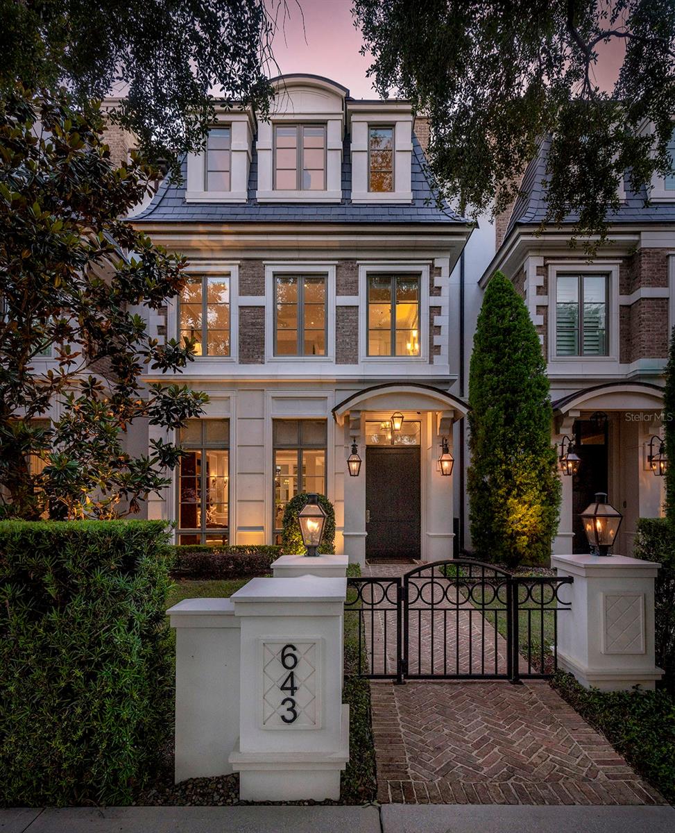 Winter Park living at its best! This custom brownstone with an exclusive Park Avenue address offers an unparalleled Winter Park lifestyle. Ideally situated in the heart of Winter Park, moments from Park Avenue’s renowned dining, boutique shopping and cultural attractions…evening strolls and friendly smiles are simply part of everyday life. An inviting front courtyard welcomes you with a brick walkway to a covered entrance flanked by stately gas lanterns. This three-story townhome offers over 4,200 square feet, a private elevator and features three en-suite bedrooms with three full and two half baths; offers generous open living, dining and kitchen spaces that overlook a private courtyard complete with a summer kitchen and so much more. Large windows throughout the home seamlessly bring the outside in and allow natural light to gently roll in. Expansive 10-foot ceilings, extensive millwork and moldings throughout, gorgeous hardwood floors, additional built-ins and French doors add to the architectural detail for an elevated living experience. A chef’s kitchen surrounds a center island with bar seating, blending into the dining and living spaces for ease of entertainment. Wolf and Sub-Zero appliances, gorgeous light cabinetry, marble details, an incredible walk-in pantry and a wet bar/butler's nook deliver great function for intimate gatherings. A two-car air-conditioned garage with loads of storage and an electric charging station round out the first-floor offerings. The second floor continues with upscale appointments, featuring a flex space with built-ins and an under-counter refrigerator that opens to an outside covered balcony. Also on this floor are a laundry room, a loft area and two large bedrooms, each with a walk-in closet and its bath. The third floor, the primary bedroom, showcases three dormers overlooking Park Avenue, storage window benches with room to relax in a tranquil setting and a luxurious primary bath with floor-to-ceiling windows, dual vanities with high-quality materials and finishes and a large glass-enclosed shower and soaking tub. Two large walk-in closets with closet systems feature a makeup vanity with a marble countertop, a mirrored backsplash and hardwood floors with beautiful light to elevate the experience. The private rooftop terrace with a fireplace, wet bar and half bath allows for the enjoyment of evening sunsets and Florida breezes. Other details include Old Carolina brick, three-story block construction, soundproof hollow core floors, precast exterior trim, a slate mansard roof and a Sonos system. There are five air-conditioning units (three of which were replaced in 2026) and three tankless gas water heaters, and the property has been meticulously cared for.