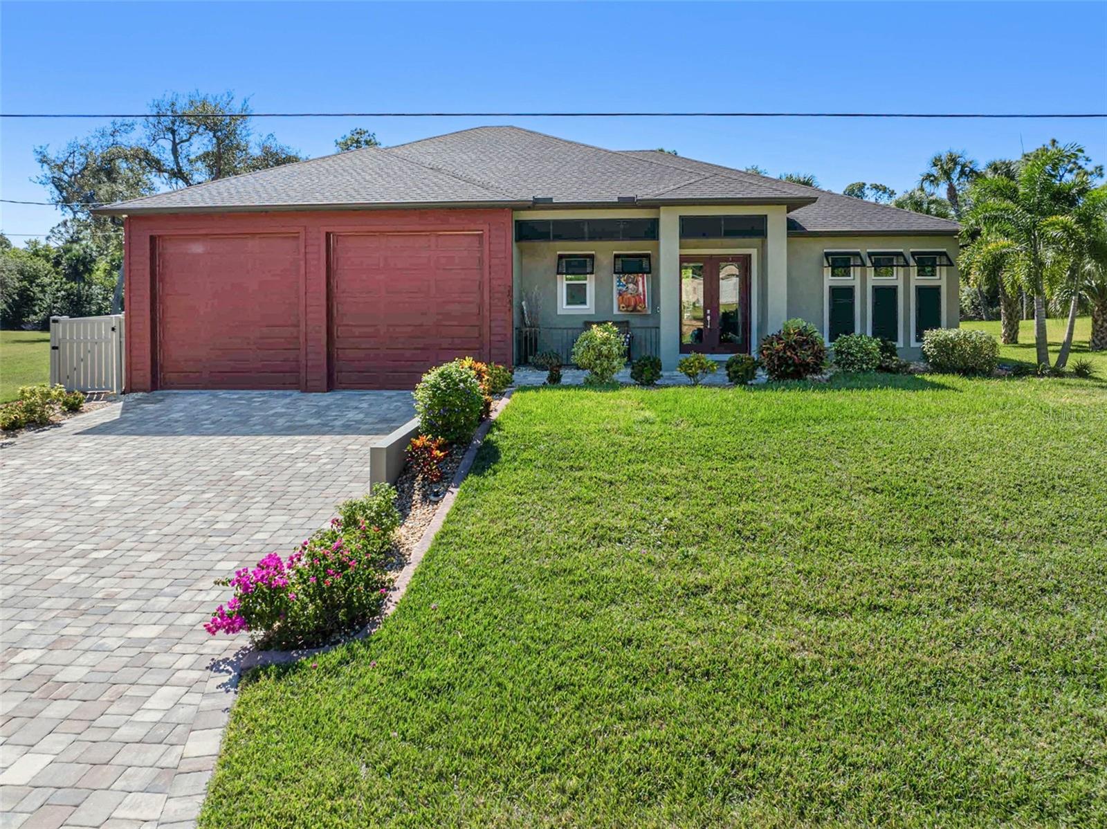 STUNNING Canal-Front Estate with heated POOL, DOUBLE LOT & Custom Upgrades Throughout. Discover exceptional craftsmanship and modern comfort in this custom-built canal-front home, perfectly situated on a double lot with an array of high-end features designed for style, efficiency, and security. Step inside to find tile floors throughout, custom wood beams in the tray ceilings, barn doors, and motorized blinds that elevate every room. The open-concept kitchen features granite countertops and flows seamlessly into the spacious living area, complete with an electric fireplace for a cozy touch. Enjoy year-round comfort and peace of mind with impact-rated hurricane windows and doors, spray foam insulation over the air-conditioned space, BATT insulation over the garage, and a whole-house R/O system. The home is fully equipped with fire sprinklers, an alarm system, and security cameras for enhanced safety. Outdoors paradise awaits! Relax by the heated pool, gather around the fire pit, or enjoy direct canal access from your private dock. The MosquitoNIX fence, fenced backyard, and irrigation system ensure easy living and low maintenance. Car enthusiasts will love the oversized 1,300 sq. ft. air conditioned garage featuring a car lift and paver driveway-a rare find offering both space and comfort. Additional upgrades include an in-ground propane tank for efficiency, custom lighting, and a beautifully landscaped yard that enhances the property curb appeal.
