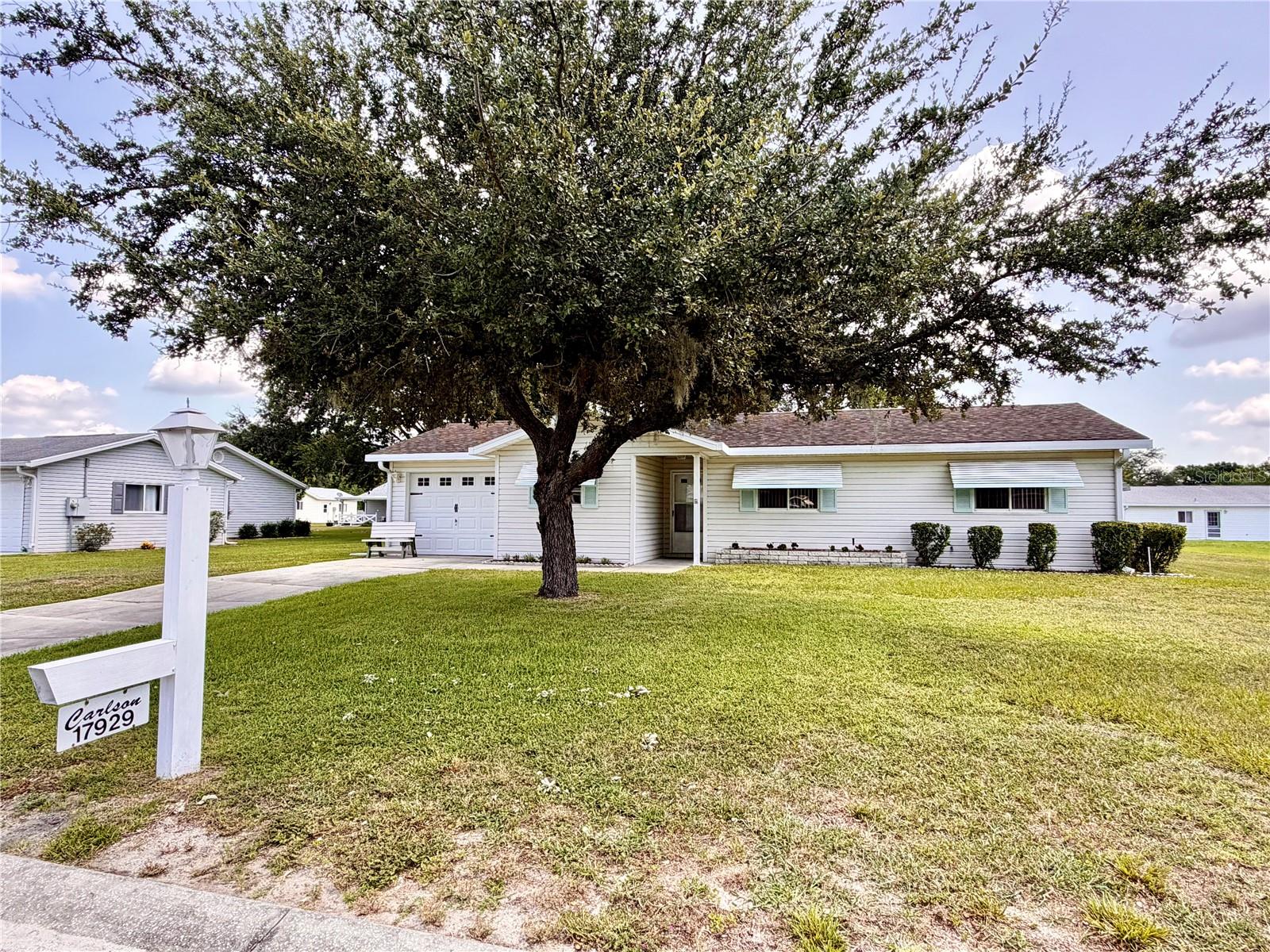 Move-in ready and available furnished (optional), this charming 2-bedroom, 2-bath home is located in the highly desirable Spruce Creek South 55+ gated golf community in Summerfield. Offering just over 1,000 square feet of comfortable living space, this turnkey opportunity is perfect as a full-time residence, seasonal getaway, or investment with excellent rental potential.

Inside, you'll find luxury vinyl plank flooring throughout and a well-appointed kitchen featuring a stainless steel refrigerator, white range with overhead microwave, dishwasher, double-basin sink, and plenty of cabinet space. The guest bedroom includes a built-in closet and is conveniently located near the guest bathroom with ceramic tile flooring and a full bathtub. The spacious primary suite offers a walk-in closet and a private ensuite bathroom with a walk-in shower.

Enjoy relaxing year-round in the enclosed Florida room, which opens to a second enclosed porch leading to a workshop/golf cart storage area—ideal for hobbies, tools, lawn equipment, or extra storage. Outside, the shaded backyard provides a peaceful setting to enjoy your morning coffee or unwind in the evenings.

The attached one-car garage adds convenience, while the community offers an active Florida lifestyle with golf, pickleball courts, clubs, social activities, and outstanding amenities. Conveniently located near shopping, dining, medical facilities, and The Villages, this move-in-ready home is a wonderful opportunity to enjoy everything Spruce Creek South has to offer.