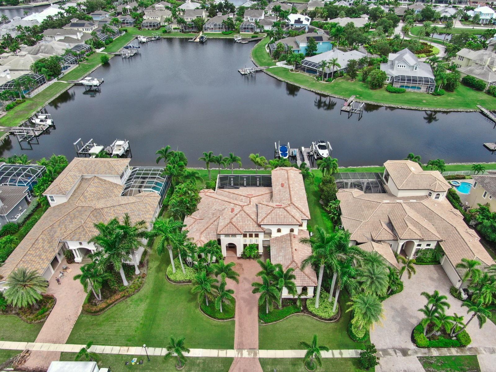 One or more photo(s) has been virtually staged. Short Sale. SELLER MUST SELL & HIGHLY MOTIVATED!! Experience the epitome of luxury living in this stunning waterfront Spanish Mediterranean home, meticulously crafted by John Cannon’s Executive Series. Nestled in the prestigious Bay Estate of Mirabay, this residence showcases breathtaking manicured landscaping featuring vibrant pink bougainvilleas, towering palms, and a grand pavered driveway that exudes an enchanting curb appeal. Step through the grand double doors and be transported to a Mediterranean charm and beyond. Every inch of this home is a masterpiece, with artistic hand-painted accents throughout. Soaring ceilings, classical columns, exposed wood beams, and intricate crown molding create an ambiance of timeless elegance. Rich Brazilian cherry hardwood floors and authentic Mexican terracotta tiles set a warm, inviting tone. Fully renovated gourmet kitchen is a culinary dream, boasting dark, luxurious cabinets, Brazilian granite countertops, a genuine copper sink, a massive island, state-of-the-art appliances, and a spacious coffee bar/pantry with a beautifully hand-carved Turkish wooden door. Large family room invites you to gather with loved ones, featuring a built-in bar ideal for crafting the perfect cocktail and creating joyful moments with guests. This space is designed for relaxed entertaining and memorable gatherings. Magnificent master suite, featuring a generous sitting area with bay windows, sliding doors to the covered lanai and pool, tray ceilings with double crown molding, and two expansive California closets. Spa-like master bath offers dual vanities, a garden tub as a focal point, and a large walk-around shower, creating a private sanctuary. On the opposite wing, discover two sizable bedrooms with elegant bathrooms, and a convenient laundry room. Notice the custom hand-carved risers as you head upstairs, where you will find a versatile bonus room with balcony access offers stunning views of the sprawling lagoon, while an additional guest suite with its own private balcony provides comfort and privacy for visitors. Other features include impact windows that offer panoramic views, while providing peace of mind during storms. Upgraded lighting and ceiling fans throughout creates a warm and inviting ambiance, accentuating the exquisite finishes and elegant architecture. Relax and unwind in the serene pool and jacuzzi overlooking the water, or enjoy the multiple outdoor sitting areas. Cozy up by the outdoor fireplace in cooler months or host unforgettable gatherings in the outdoor kitchen and grill area. Included with the property is a meticulously maintained 27-foot Crownline boat, a 2003 model that has recently undergone a complete rebuild. A powerful 10,000-pound boat lift is also included, providing secure and easy mooring for your vessel. Whether you’re hosting gatherings, enjoying mornings on the water, this property offers the perfect combination of elegance, functionality, and recreational opportunity. Located within the Mirabay community, you'll have access to a host of amenities for every family member—tennis, pickleball, resort-style pools, a large lagoon for water sports, dog parks, playgrounds, and more. This exquisite home offers the perfect blend of artistic elegance, modern luxury, and vibrant community life—an extraordinary place to call home.