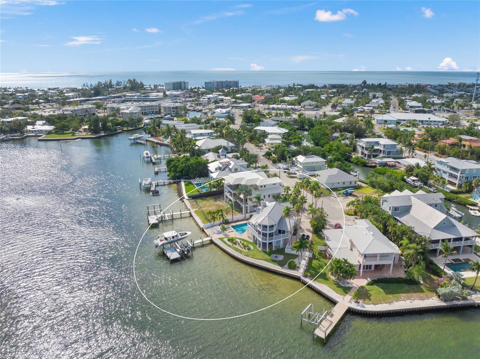 Coastal Waterfront Retreat with Panoramic Bay Views
Experience the best of coastal living in this beautifully updated waterfront home overlooking the Intracoastal Waterway and Tampa Bay. Designed by local architect Emily Ann Smith, this 3-bedroom, 2.5-bath residence perfectly blends timeless island charm with modern coastal elegance.
Located on a quiet cul-de-sac in the heart of Holmes Beach, this home welcomes you with an open-concept layout filled with natural light and expansive water views. The living area features a wood-burning fireplace and large windows framing the ever-changing waterfront scene of boats passing and dolphins playing. Step through to the spacious screened patio, ideal for morning coffee or an evening glass of wine as the sea breeze drifts through.
The chef’s kitchen is both stylish and functional, featuring a large center island, wine refrigerator, and designer finishes—perfect for entertaining or casual island dining. Two guest bedrooms and a shared bath, plus a half bath and elevator access, complete the main level.
Upstairs, the private master suite offers a peaceful retreat with its own screened porch and panoramic water views, creating a serene space to unwind and take in the beauty of the bay.
Outside, a tropical backyard oasis features lush landscaping, a heated pool, and a private dock equipped with two new boat lifts—including a 20,000-lb lift and two jet ski lifts. Enjoy effortless access to the Intracoastal for boating, fishing, or a sunset cruise to nearby waterfront dining.
Additional highlights include a covered outdoor area perfect for an outdoor kitchen or lounge, a side-entry garage, and extra storage for all your beach and boating essentials.
Walking distance Anna Maria Island’s pristine Gulf beaches, boutique shops, and coastal restaurants, this home captures the essence of relaxed island sophistication.
A true coastal sanctuary—where every day feels like a getaway!