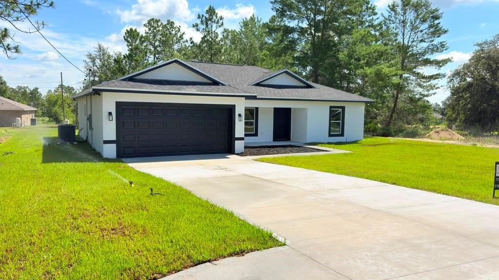 Stunning Designer fluted stone accent wall – A Must-See! Discover this gorgeous, newly constructed home nestled in the serene setting of Ocklawaha  with standout features you won't find everywhere: WASHER + DRYER included and a CUSTOM DESIGNED WALK IN CLOSET in the master suite. From the moment you arrive, you'll notice the thoughtfully placed spotlights that brighten all four corners of the property, adding both style and security. Step onto the inviting back porch, where a ceiling fan ensures your comfort as you relax outdoors.

Inside, the open floor plan immediately impresses with its modern finishes and elegant design. The kitchen and bathrooms feature luxurious quartz countertops, while recessed lighting bathes the entire living area in a warm, welcoming glow. The kitchen is fully outfitted with essential appliances, including a dishwasher, refrigerator, stove, and microwave — and the dedicated laundry area comes complete with a full-size washer and dryer, making this home truly move-in ready from day one.

Enjoy the privacy of a split floor plan, with the spacious master suite thoughtfully separated from the guest bedrooms. The master bedroom is a true retreat, featuring a tray ceiling and an en-suite bathroom with upscale touches. The custom walk-in closet is a standout on its own, thoughtfully designed with dedicated hanging space for shirts and dresses, open shelving for folded items and accessories, and built-in drawers — a complete, organized storage solution rarely found at this price point.

On the guest side, the generously sized guest bedrooms are complemented by a well-appointed guest bathroom, offering comfort and convenience for family and visitors. Modern light fixtures and ceiling fans are thoughtfully placed throughout the home, enhancing every room with style and practicality. As an added bonus, Spectrum internet service is available, ensuring you stay connected. Don't miss your chance to own this exceptional property! Schedule your showing today and experience everything this home has to offer.