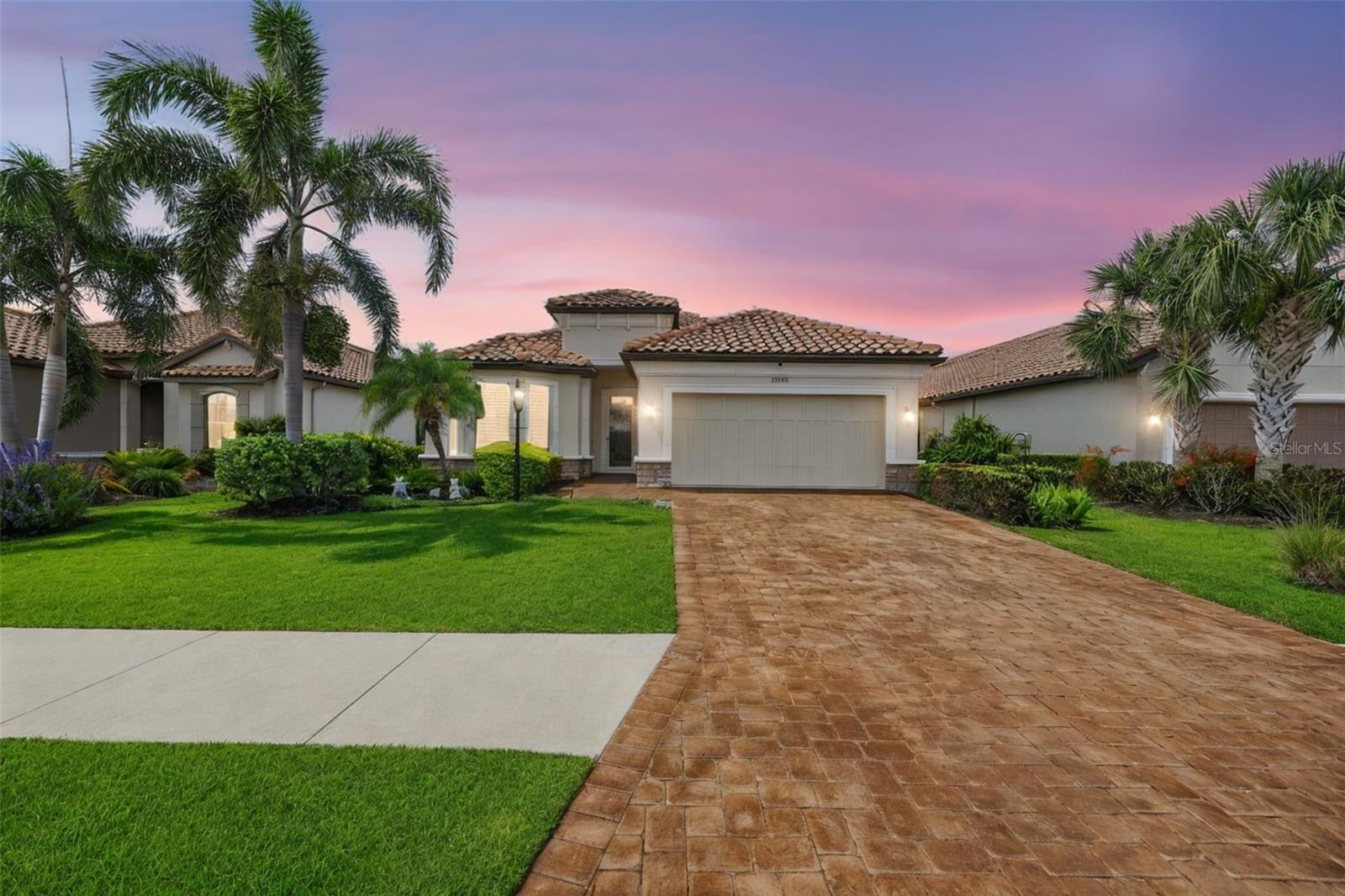 Welcome to 13202 Prima Drive, an exceptional residence offering 2 bedrooms, 2 bathrooms plus a den, where refined design and modern sophistication come together in perfect harmony. Thoughtfully designed for both elegant entertaining and everyday comfort, this open-concept home is anchored by a stunning oversized island with abundant storage, complemented by rich granite countertops and a designer tile backsplash. The primary suite is a private sanctuary, featuring a beautifully appointed ensuite bath and curated finishes that evoke a sense of tranquility and retreat. Throughout the home, plantation shutters, custom privacy shades, while a hot water recirculation system ensures effortless convenience. Smart home innovation and security are seamlessly integrated, including a Google Nest doorbell and thermostat, a comprehensive ADT security system, and cameras positioned both inside and out, offering ultimate peace of mind. Step outside to an extraordinary lanai oasis designed to rival a private resort. Motorized sun and rain shades, privacy screens, and a bespoke outdoor kitchenette with a soapstone countertop create a luxurious setting for entertaining. The grounds are highlighted by a newly enhanced, whole-home water feature system with an advanced algae control system, showcasing tranquil waterfalls, flowing streams, and lush tropical landscaping with swaying palms. Designed with lifestyle in mind, the home also features a custom pet retreat, including a 10x10 artificial turf dog run with irrigation and a convenient doggy door for seamless indoor-outdoor living. Additional enhancements include an upgraded garage with epoxy flooring, insulated ceilings, and a dedicated workshop space, blending functionality with thoughtful design. This is more than a home—it is a private sanctuary where luxury, comfort, and elevated living converge.  Living in Esplanade is like being on vacation every day. The community is built around healthy living and living well with unlimited exercise and social options. Esplanade offers a wide array of amenities and activities such as an 18-hole championship golf course, two resort pools, hot tubs, resistance pool, pickleball, tennis, bocce ball, two fitness centers, exercise classes, two dog parks, playground, firepit, spa/salon, an on-site lifestyle director, social events, and various clubs. The state-of-the-art Culinary Center offers residents several dining options such as the Barrel House Bistro, Bahama Bar, as well as catering services, wine tastings, and special events. Esplanade is located in the heart of Lakewood Ranch, close to I-75, Lakewood Ranch Main St., University Town Center, Sarasota Polo Club, shopping, dining, entertainment, hospitals, cultural attractions, boating, parks, and Florida’s famous sandy beaches. THE BLINK CAMERAS AND GOOGLE CAM DO NOT CONVEY. Living room sofa, lanai furniture and living room area rugs convey.