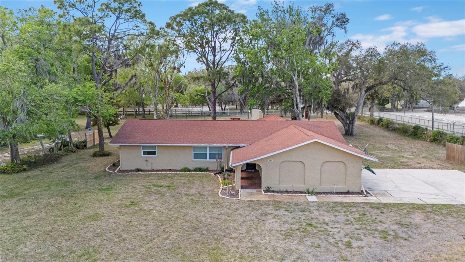 This inviting single-family home offers 3 bedrooms and 2 full bathrooms on a spacious 0.86-acre lot. The kitchen features granite countertops, a tile backsplash, and a pantry with plenty of storage. The large master bedroom includes a walk-in closet and a private en-suite bath with double vanities and a relaxing soaker tub. Gather around the cozy wood-burning fireplace in the family room. Enjoy extra year-round living space in the air-conditioned Florida room, plus relax on the covered back porch. Fenced backyard (5-foot fencing) and includes two sheds for extra storage. A 2-car garage rounds out the property. This home has generous indoor and outdoor space in a peaceful setting.