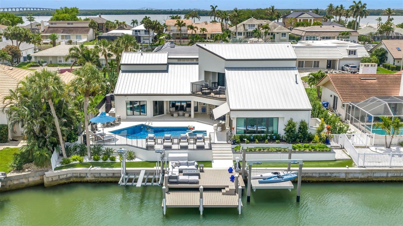 MODERN MASTERPIECE in the prestigious gated waterfront community of Bayway Isles in St. Petersburg, Florida. Extensively redesigned and enhanced throughout 2025, this extraordinary luxury waterfront residence blends timeless sophistication with contemporary elegance, creating a truly elevated living experience.
Spanning approximately 4,446 square feet, the home showcases striking contemporary architecture, expansive open living spaces, and impeccable designer finishes throughout. A dramatic two-story living room is framed by spectacular new Origin folding doors that seamlessly connect the interior to the breathtaking waterfront setting and resort-style outdoor entertaining areas. Rich wood flooring, Italian marble finishes, designer lighting, and custom details elevate every space.
Premium 2025 upgrades include all new bronze PGT impact windows and doors, custom draperies and plantation shutters, Halo whole-house water filtration system, extensive garage storage additions, and integrated smart home enhancements.
The luxurious first-floor primary suite offers a private retreat complete with fireplace, oversized custom walk-in closet, and elegant “Good Morning” coffee bar. The spa-inspired primary bath features exquisite marble finishes, soaking tub, dual vanities, and an oversized dual-head shower, creating a true resort-inspired atmosphere within the comfort of your own home.
Designed for both everyday living and entertaining, the gourmet kitchen features GE Monogram Statement appliances, a 48-inch six-burner gas range with double ovens, French-door wall oven, built-in Miele coffee station, dual refrigerators, four freezer drawers, custom cabinetry, and a stylish wet bar with wine cooler overlooking the water. The adjacent family room has been enhanced with an immersive Sonos audio system and custom motorized TV lift for an exceptional entertainment experience.
Outdoor living rivals a private waterfront resort with a marble-topped outdoor kitchen, commercial-grade hybrid gas and wood grill, expansive travertine terraces, sparkling pool, and custom waterfront bar area complete with beverage center and ice maker — all thoughtfully designed for unforgettable entertaining and relaxed waterfront living.
Boating enthusiasts will appreciate the deep-water dock with extension landing, dual lifts, and quick access to open water with no fixed bridges.
Perfectly positioned near I-275, this is one of the best commuting waterfront locations in Tampa Bay — approximately 4 minutes to the beaches, 10 minutes to Downtown St. Petersburg, and 25 minutes to Tampa International Airport.
Bayway Isles is renowned for its 24/7 guarded gate security, beautifully maintained surroundings, and exclusive waterfront lifestyle, making it one of St. Petersburg’s premier luxury gated communities.
This exceptional estate is far more than a home — it is a statement of modern luxury, craftsmanship, and waterfront living without compromise.
Furnishings may be available separately under a separate agreement.
Schedule your private showing today and experience one of St. Petersburg’s finest luxury waterfront homes.