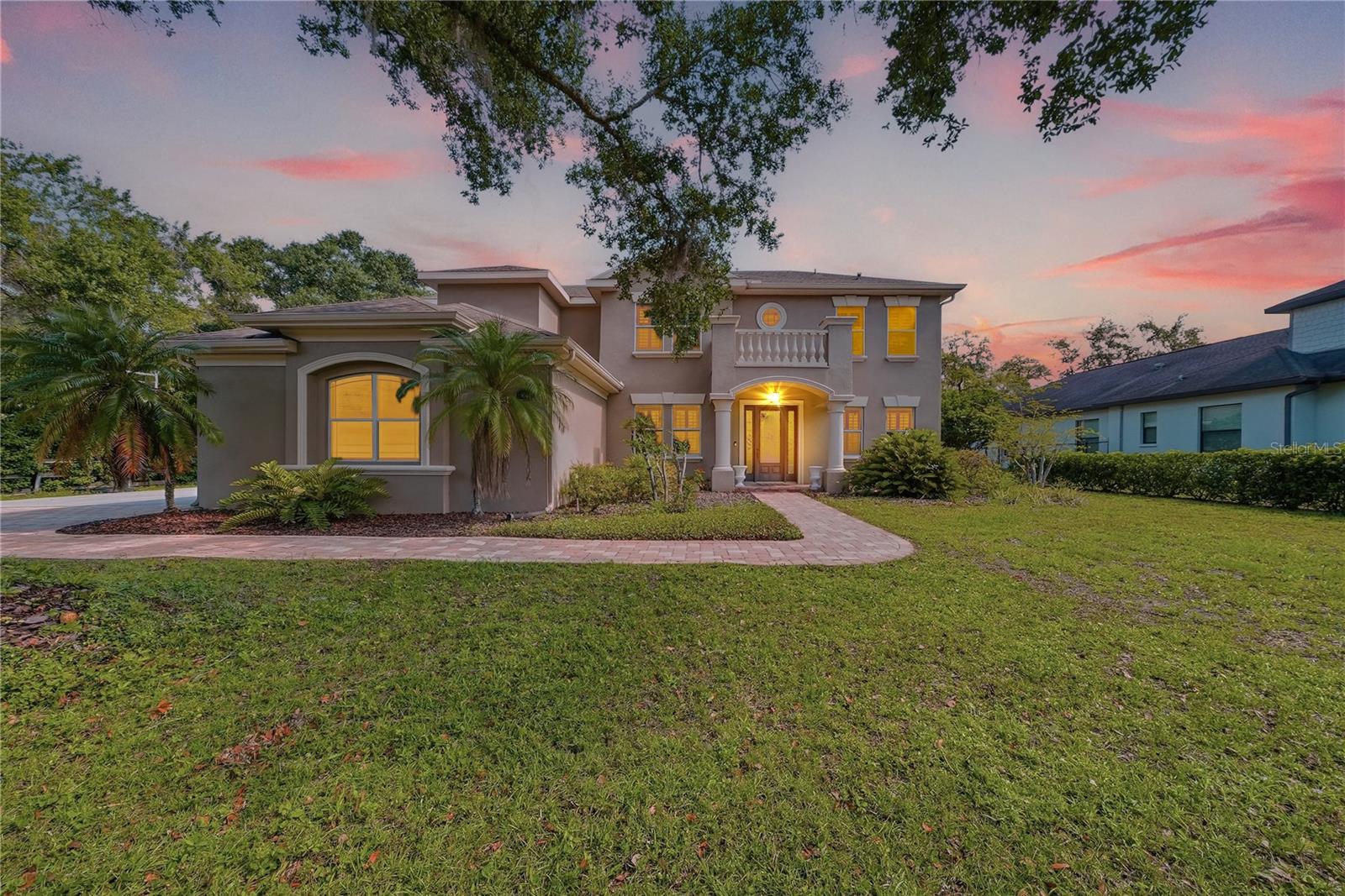 Virtually Staged. Welcome home to a rare Odessa retreat where acreage, comfort, and everyday luxury come together. Set at the end of a quiet street on 1.51 ACRES, this 5 bedroom, 3.5 bath pool home offers the freedom of AGRICULTURAL zoning with the space and flexibility buyers love. Inside, soaring ceilings, natural light, and an open layout create a bright, welcoming feel from the moment you walk in. The chef's kitchen offers an abundance of cabinetry and counter space, flowing effortlessly into the dining and living areas with a wet bar that makes entertaining effortless. Two bedrooms are located downstairs, including one with an ensuite cabana bath, ideal for multigenerational living or extended guests. Upstairs, the primary suite feels like a quiet escape with a balcony overlooking the backyard. Two additional spacious bedrooms are adjoined by a Jack and Jill bath with a private vanity on each side. Outside, the fully fenced backyard feels like your own resort with a HEATED SALTWATER POOL AND SPA, mature greenery, and room for entertaining, animals, gardening, or quiet evenings under the Florida sky.  Located in a HIGHLY RATED SCHOOL DISTRICT, Odessa provides the rare combination of serene living and convenience. Hard to find, and even harder to forget.