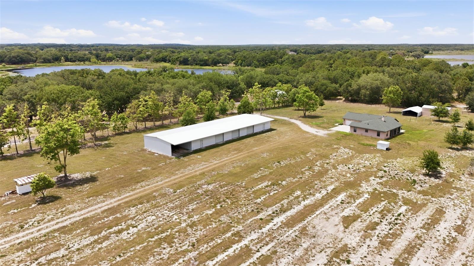 Car Enthusiast ... Looking for a home for your collection or maybe you own your own business which involves heavy machinery. Agricultural exempt 14-acre property featuring approximately 7 acres of pines, 4-acre homesite, and
3.43 acres of wetlands. Built in 2005, this 3-bedroom, 2-bath home offers approximately 1,727 square
feet with a split floor plan, fireplace, updated flooring throughout, quartz countertops, custom Poplar
and Red Oak shelving, tile shower, and dual sinks in the primary suite with a garden tub. Additional
updates include a 2025 hot water heater, newer roof (2018), and HVAC (2020). Property improvements
include an underground irrigation system, diesel 8-inch well, replaced well tank, natural spring/water
feature beneath the property, and goat wire fencing on three sides. The commercial-grade metal
agricultural utility building features Red Oak and Poplar finishes throughout, three garage openings with
mini-split A/C and heat, approximately 128 yards of concrete, and 150 MPH hurricane rating
construction. Main structure measures approximately 120x40 with three 12x10 doors. Full-size tractor
will go in and out with ease. Designed with an approximate 50-year lifespan consideration by Inland
Buildings. Additional structure includes workshop (approximately 400 square feet) with 2 - 8x8 roll-up
doors, and a wall A/C unit. Outdoor buildings and storage structures included. Perfect for someone who
wants privacy, space, and freedom while being close to Eustis, Mt. Dora and The Villages. You might love
the idea of acreage, wildlife, gardening, or hobby farming and have livestock. Maybe you need room for
toys, tractors, RVs, boats, or equipment. Own your own tradesman business! And huge bonus; No HOA!