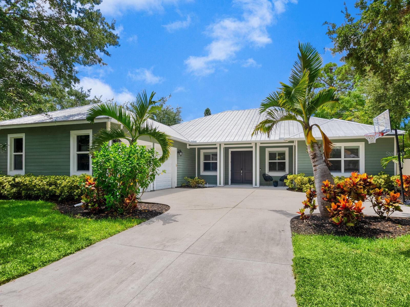One or more photo(s) has been virtually staged. Ideally positioned in Sarasota’s desired West of Trail, this 2012 custom-built three-bedroom, four-bath home blends timeless architecture with modern comfort—just a short stroll to Southside Village’s boutiques and cafés, Selby Gardens, the bay front, and Sarasota Memorial Hospital. Set on a fully fenced, 1/3-acre lot in the sought-after Southside Elementary district, the property offers a private oasis with a sun-soaked southern-exposure backyard—ideal for all-day light on the pool and covered patio. Outdoor living shines with a heated pool featuring a sun shelf, fire pit, landscaped lawn, and inviting front and back porches designed for effortless entertaining. Inside, nearly 2,800 square feet unfolds with a wood-burning fireplace, tile and luxury vinyl plank flooring, and a flexible layout suited for today’s lifestyle including a den/office that can easily be used as a fourth bedroom. The oversized laundry/mudroom streamlines daily life, while the two-car garage with extra storage adds convenience. The spacious primary suite opens directly to the pool and features dual walk-in closets and bath with double vanities, a walk-in shower, and soaking tub. Built with quality in mind—including block construction and a durable metal roof—this home offers peace of mind and enduring value. A rare opportunity to own newer construction West of Trail with accessibility, abundant natural light, and room to live the Sarasota lifestyle to its fullest—just minutes from downtown.