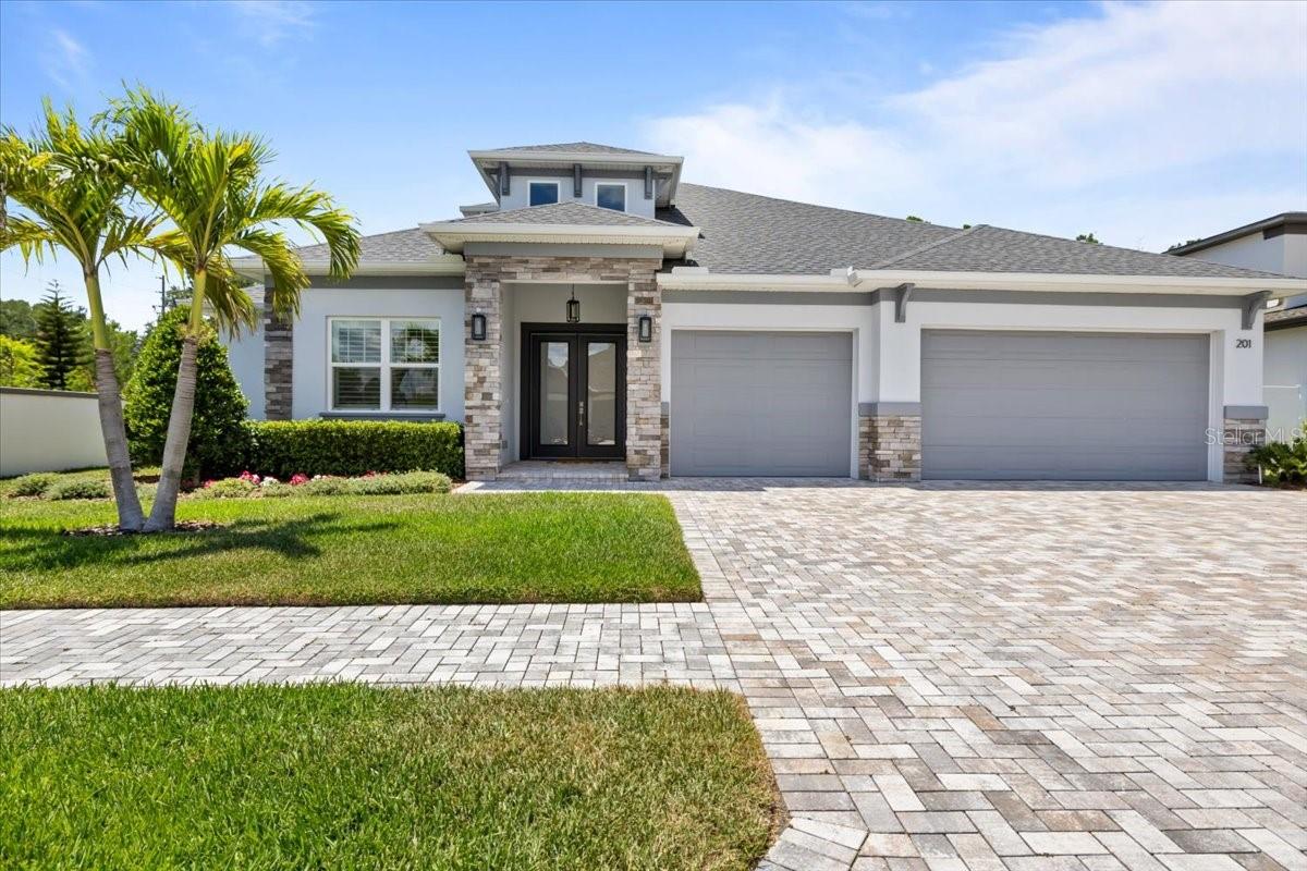 Welcome to LaRocca Estates, an exclusive gated enclave of just seven custom homes in desirable Palm Harbor. This beautifully designed residence offers nearly 2,600 square feet of living space with 5 bedrooms, 3 bathrooms, and a 3-car garage, blending an open-concept layout, volume ceilings, quality craftsmanship, newer fans, and new plantation shutters throughout. The kitchen is both stylish and functional, featuring shaker cabinetry, quartz countertops, a center island with contrasting cabinetry, a designer backsplash, stainless steel appliances, and upgraded fixtures. Luxury flooring flows through the main living areas, creating a warm and cohesive feel. The spacious primary suite offers a walk-in closet and a spa-inspired bath with dual cabinetry, quartz counters, custom tile finishes, and upgraded fixtures. There is also a perfectly situated additional bedroom in the front of the home, perfect for office or guest space. A second-floor bonus room or additional bedroom with its own ensuite bath and large walk-in closet provides ideal flexibility for guests, a home office, or multigenerational living. Step outside and enjoy a covered lanai along with a private outdoor family pavilion complete with an outdoor kitchen, grill, and fire pit, perfect for entertaining year-round. With curated interior and exterior finishes, modern ebony and charcoal accents, and a boutique setting in one of Palm Harbor’s most desirable gated communities, this home offers comfort, style, and privacy. Zoned for Palm Harbor University High School and conveniently located near shopping, dining, Old Downtown Palm Harbor, area beaches, and major commuter routes. A rare opportunity to own a custom home in an intimate gated neighborhood. Schedule your private showing today.