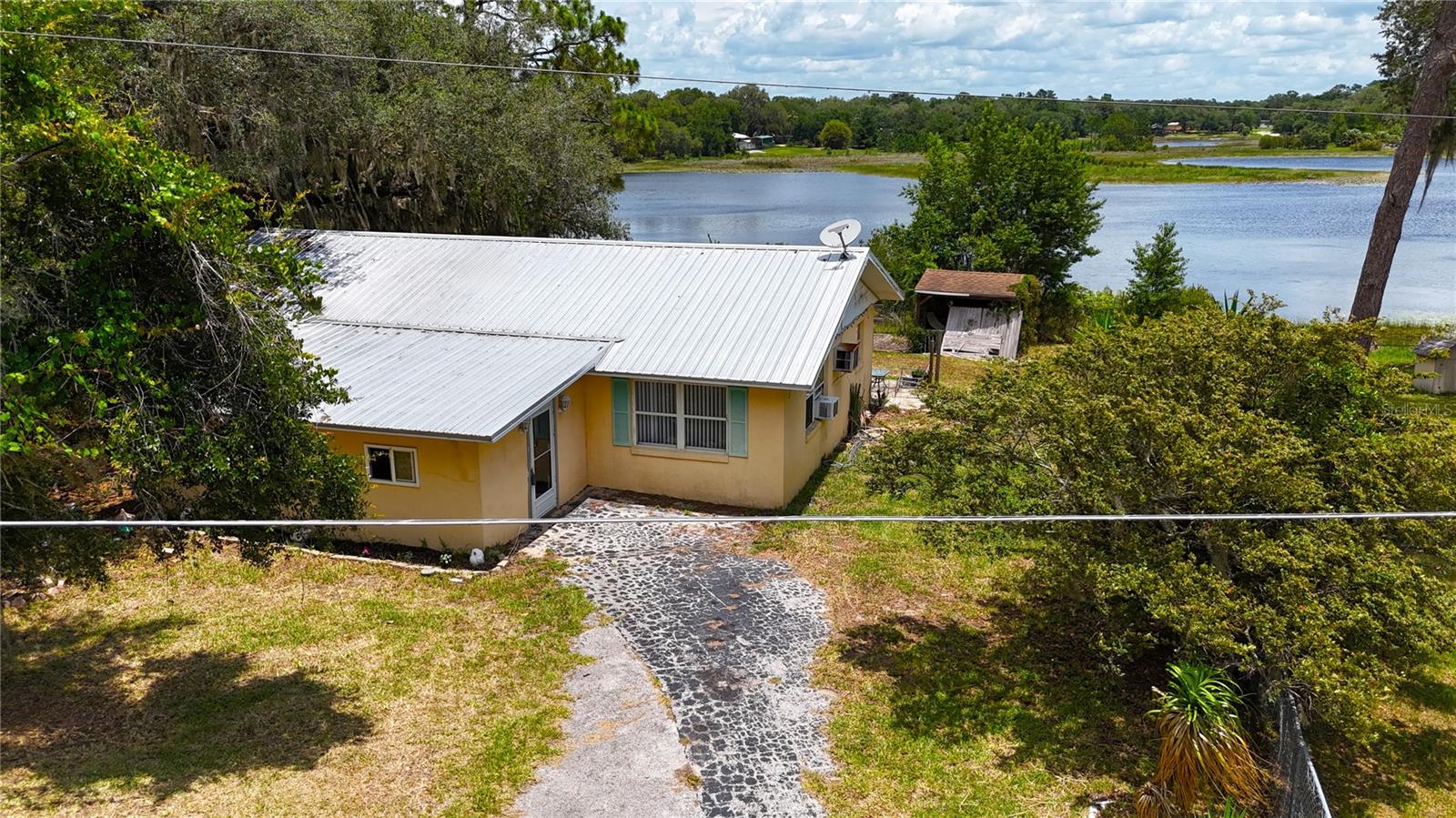 ALWAYS WANTED TO LIVE ON THE WATER SURROUNDED BY NATURE?? HERE IS YOUR OPPORTUNITY. CONCRETE BLOCK 3 BDRM 1 ½ BATH HOME ON LAKE PLACID WITH BEAUTIFUL VIEWS AND ABUNDANT WATERFOWL AND SANDHILL CRANES…NOT TO MENTION THE FISHING!! LARGE ENCLOSED PORCH GREETS YOU AND IS IDEAL FOR PLAYROOM, STORAGE OR WHATEVER SUITS YOUR LIFESTYLE NEEDS. LIVING ROOM IS SPACIOUS WITH LUXURY VINYL FLOORING AND OPEN TO THE DINING AREA AND KITCHEN BOTH WITH TILE FLOORING. KITCHEN HAS GOOD STORAGE, WOOD CABINETS, NEWER APPLIANCES AND GRANITE COUNTERTOPS PLUS A BREAKFAST BAR!! AN OFFICE OR DEN OVERLOOKS THE LAKE AND LEADS TO AN OPEN PATIO FOR RELAXING AND ENJOYING THE VIEWS. PRIMARY AND 2ND BDRM HAVE NEWER CARPET AND 3RD BDRM HAS LUXURY VINYL FLOORING. ALL HAVE GOOD CLOSET SPACE AND ARE NICE SIZE. INSIDE LAUNDRY ALSO HAS A SHOWER AND TOILET. WATERFRONT IS FENCED FOR THE PROTECTION OF YOUR PETS OR CHILDREN AND THERE IS A GAZEBO (NEEDS WORK) AND A STORAGE BUILDING AS WELL. ACROSS THE STREET SERENE ACREAGE PROVIDES PASTORAL VIEWS AND IS PART OF AN UPSCALE COMMUNITY OF RANCH PROPERTIES. HOME HAS REPLACEMENT WINDOWS AND METAL ROOF TOO SO WORRY FREE!! EASY ACCESS TO THE OCALA NATIONAL FOREST AND OCKLAWAHA RIVER AND STILL AN EASY DRIVE TO OCALA, BELLEVIEW, THE VILLAGES AND DAYTONA!! UNBEATABLE PRICE FOR A WATERFRONT HOME!!!