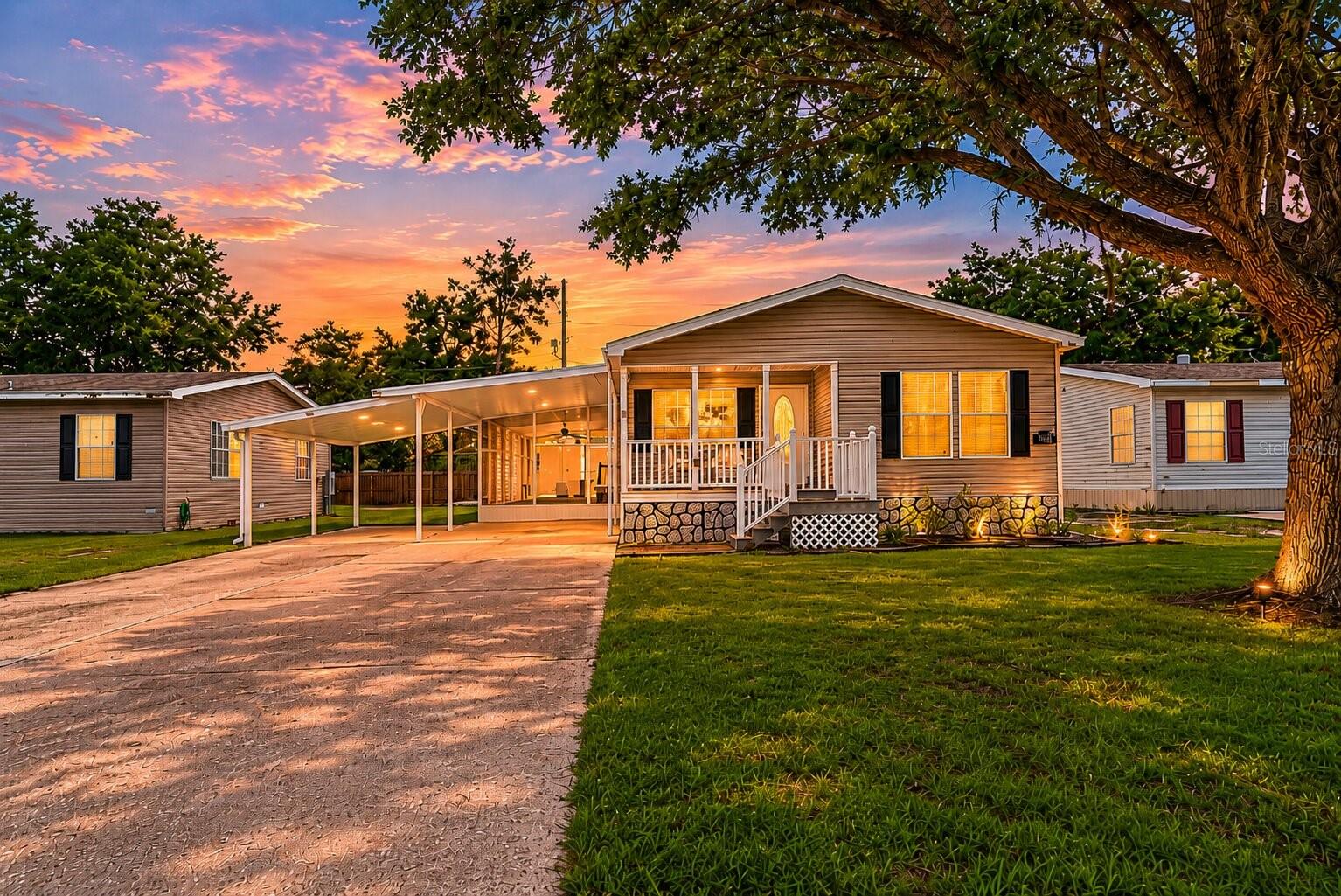 NO HOA & YOU OWN THE LAND! This beautifully maintained and thoughtfully upgraded home offers approximately 1,650 square feet of comfortable living space (under air) and an incredible amount of indoor and outdoor functionality. 
One of the standout features of this property is the enormous screened Florida room — a space rarely found at this size. Complete with durable epoxy flooring, functional privacy screens, and double-door access, this versatile area is ideal for entertaining, enjoying your morning coffee, hosting family gatherings, or simply embracing Florida's beautiful weather year-round.
From the moment you arrive, you'll appreciate the charming covered front porch, extended driveway with parking for multiple vehicles, and the massive two-car carport that provides exceptional convenience for homeowners and guests alike. The home's upgraded skirting not only enhances curb appeal but also allows for easy crawlspace access and maintenance. The roof was replaced in 2020!
Inside, you'll find an inviting open-concept floor plan filled with natural light and enhanced by upgraded luxury vinyl plank flooring throughout. The spacious living area features a cozy wood-burning fireplace, creating the perfect gathering space for relaxing evenings at home. The kitchen is designed with both style and practicality in mind, showcasing beautiful granite countertops, an induction cooktop, extended cabinetry for additional storage, and ample workspace for preparing meals and entertaining guests.
The primary suite includes a massive walk-in closet and generous living space, while the sizable indoor laundry room provides additional storage and everyday convenience.
Outside, a well-maintained storage shed with ramp access provides the perfect place for tools, lawn equipment, hobbies, or seasonal décor. Every aspect of this property has been carefully maintained, making it truly move-in ready.
Located in a friendly and peaceful community, you'll enjoy convenient access to shopping, dining, medical facilities, major highways, Orlando attractions, and Florida's beautiful beaches without the hassle of HOA fees. 
If you've been searching for a home that combines functionality, modern updates, and a great location at an affordable price, call us today to schedule your private showing!