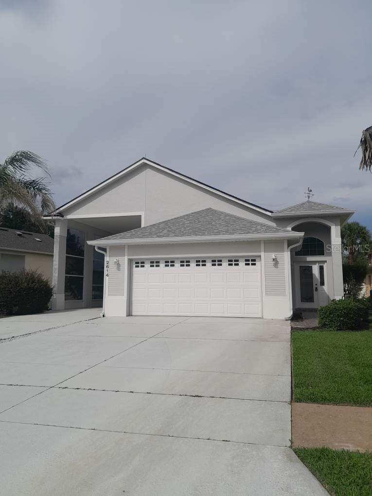 LOCATION! LOCATION! LOCATION!  EAST FACING WATER VIEW!   NO REAR NEIGHBORS!  This is a one-story RV PORT HOME IN CENTRAL FLORIDA which keeps your prized vacationing asset from the harsh elements until you are ready to venture out once more. About a 46’ RV port is PROTECTED under-roof; and is COMPLETE WITH 50/30 AMP service, DEDICATED SEWER & water service to make connections easy. Port has recessed lighting, NEW SCREENING and 2 convenient entrances into the house. House guests may use the extra accommodations offered by your RV!  2-CAR GARAGE complete with AC splitter work or play inside in comfort.  NEW ROOF IN 2023 by APC ROOFING.  A PRIVATE, DEDICATED IRRIGATION WELL offers free garden watering (a rare and wonderful asset).  Inside note BRAND NEW PLANK TILE FLOORING THROUGHOUT the house.  Kitchen has GRANITE counters with BREAKFAST BAR, Stainless Steel appliances (stove is being replaced) and cabinet pantry.  Cabinets offer great storage. OWNERS' SUITE has one walk-in closet with shelving for more storage convenience.   This bedroom has an ensuite bathroom with shower and 2 sinks. The guest bedroom is big enough for a queen bed. The second bath has garden tub & shower combo. Owners converted the screened-in porch into an enclosed FLORIDA ROOM off the dinette area.  Relax here or go outside onto the stamped cement patio which follows the breadth of the house and wraps around into the side walkway.  You can access the RV port from this side walkway.  NEW PAINT INSIDE AND OUTSIDE.   Newer Downspouts and Gutters!  Some maintenance items remain.   Citrus Highlands Phase 1 is an elite RV Port Home community which enjoys an affordable HOA, community pool and clubhouse, situated in popular Clermont within easy minutes of Disney attractions & state park recreation!