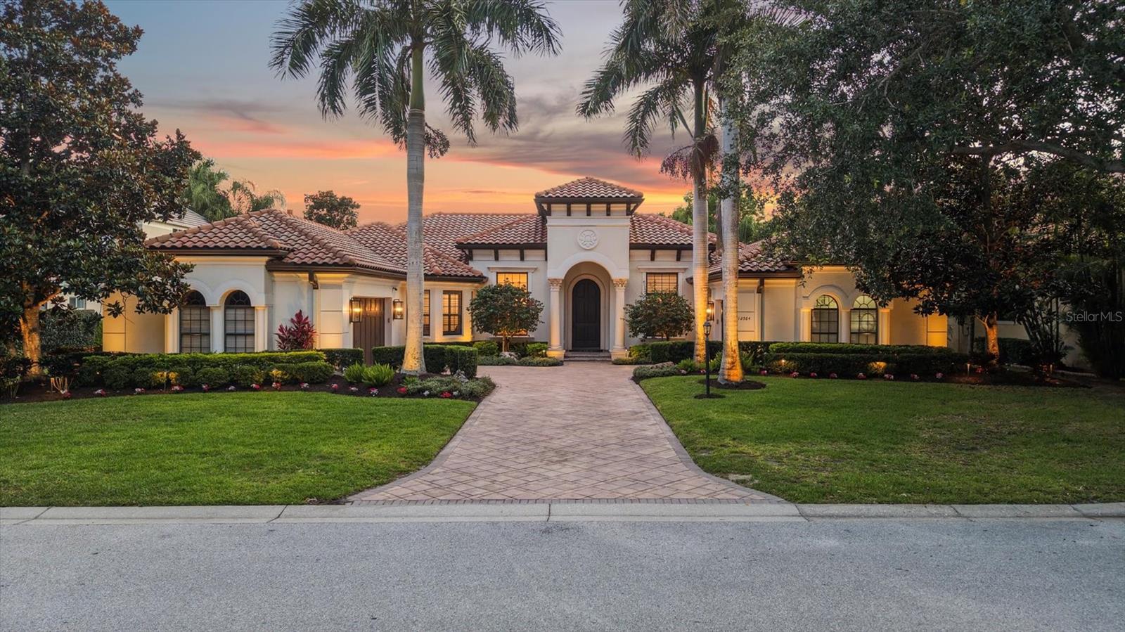 Perfectly positioned within the gates of Lakewood Ranch Country Club, 12564 Highfield Circle presents an exceptional opportunity to experience elevated Florida living in one of the area’s most sought-after luxury communities. Thoughtfully remodeled in 2020 with extensive high-end upgrades and designer finishes throughout, this stunning Anchor Built residence effortlessly blends timeless elegance with modern upgrades while offering an atmosphere of warmth, comfort, and refined style. From the moment you arrive, the home captivates with its manicured landscaping, impressive curb appeal, and welcoming presence, creating an unforgettable first impression. Inside, the beautifully reimagined interior showcases a seamless open-concept design enhanced by rich engineered wood flooring that flows throughout the main living spaces, creating a cohesive and luxurious aesthetic. Natural light pours through expansive windows and glass doors, highlighting the home’s elegant architectural details, updated lighting fixtures, and carefully curated finishes that elevate every room. Designed with both entertaining and everyday living in mind, the spacious gathering areas offer an effortless flow between formal and casual spaces, providing the perfect backdrop for intimate evenings or large-scale gatherings with family and friends. Superior finishes, abundant cabinetry, premium surfaces, and stylish details contribute to the kitchen’s impressive design while maintaining functionality and comfort. One of the home’s most distinctive features is the custom wine wall, creating a dramatic focal point that adds both elegance and contemporary flair to the interior while offering a unique space to display and enjoy a curated wine collection. The luxurious primary suite serves as a private retreat with tranquil surroundings and a spa-inspired atmosphere designed for ultimate relaxation. The extensively renovated bathrooms throughout the home were thoughtfully redesigned in 2020 and now feature four beautifully updated spaces with modern vanities, designer tilework, premium fixtures, frameless glass showers, and discerning finishes that create a true luxury experience. Every bathroom reflects exceptional attention to detail and a commitment to quality craftsmanship. Three additional guest suites provide comfort and privacy for family and visitors alike while offering flexibility for a home office, fitness room, or additional lounge space. The outdoor living areas continue the home’s impressive appeal, providing the ideal setting to embrace Florida’s year-round sunshine and indoor-outdoor lifestyle. Whether enjoying a peaceful morning coffee, entertaining guests, or relaxing at sunset, the outdoor spaces create a private oasis surrounded by lush tropical landscaping and the serene ambiance that defines Lakewood Ranch Country Club living. Residents enjoy access to beautifully maintained surroundings, optional golf and social memberships, championship golf courses, tennis, fitness amenities, and proximity to world-class dining, shopping, top-rated schools, and the vibrant attractions of Lakewood Ranch and Sarasota. Combining luxurious renovations, elegant design, and an exceptional location, 12564 Highfield Circle offers a rare opportunity to own a beautifully updated residence in one of Southwest Florida’s premier country club communities.