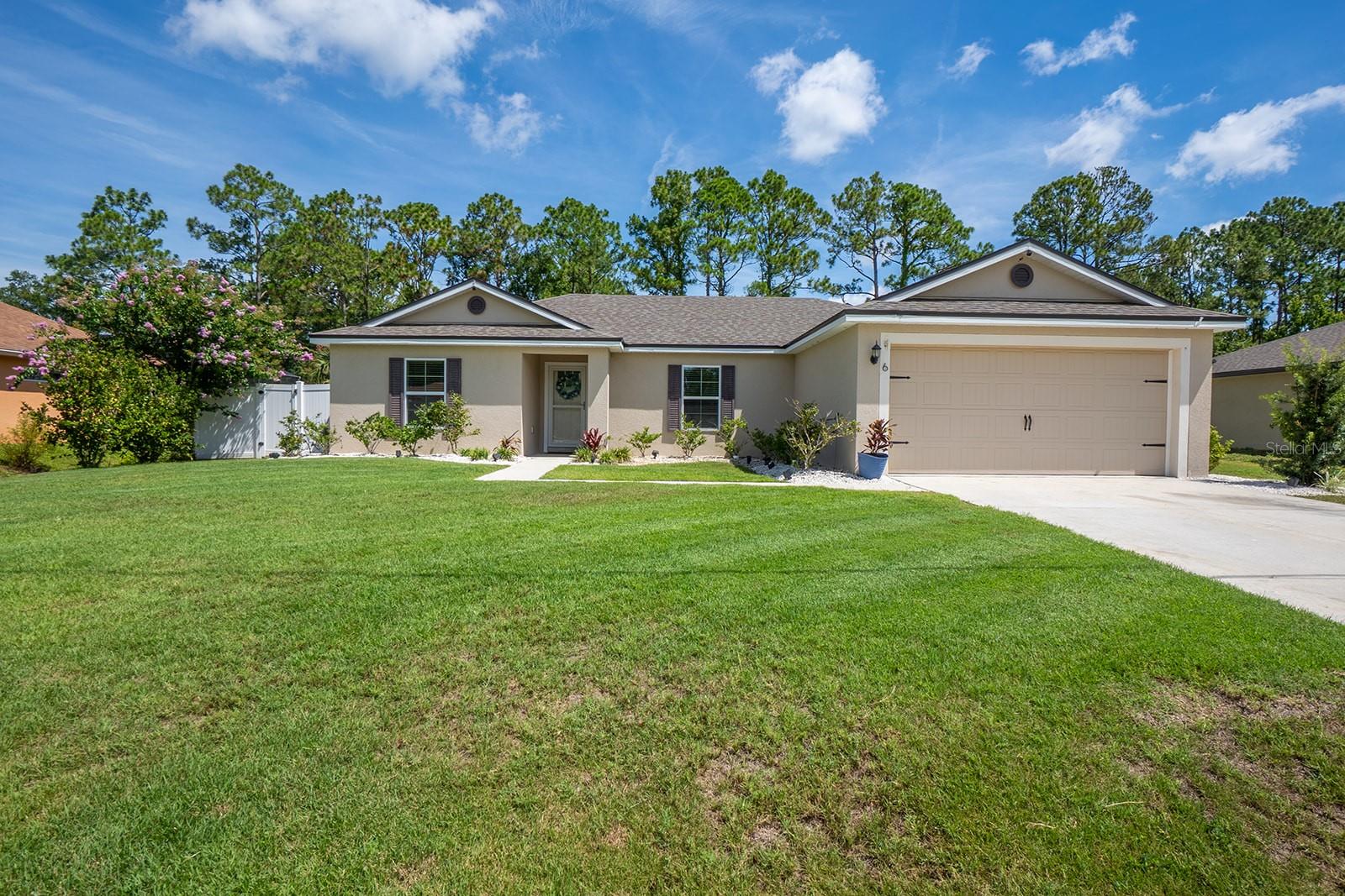 Stunning Florida pool home featuring the popular Caladesi floor plan! This beautifully maintained 3-bedroom, 2-bath home offers an open-concept, split floorplan with a spacious great room, dining area, and an inviting kitchen complete with granite countertops, wood cabinetry, energy-efficient appliances, and abundant storage. Upgraded flooring and an integrated whole-home sound system add style and convenience throughout. Step outside to your private backyard oasis featuring a sparkling saltwater pool with a Baja shelf, an elegant travertine pool deck, and a fully fenced yard—perfect for relaxing, entertaining, or enjoying the Florida sunshine. The welcoming covered front entry, lush landscaping, and attached garage complete the home's exceptional curb appeal. Located in the heart of Palm Coast, you'll enjoy easy access to parks, conservation areas, shopping, dining, world-class golf, and beaches. Move-in ready and loaded with upgrades, this home offers the perfect blend of comfort, luxury, and the Florida lifestyle.