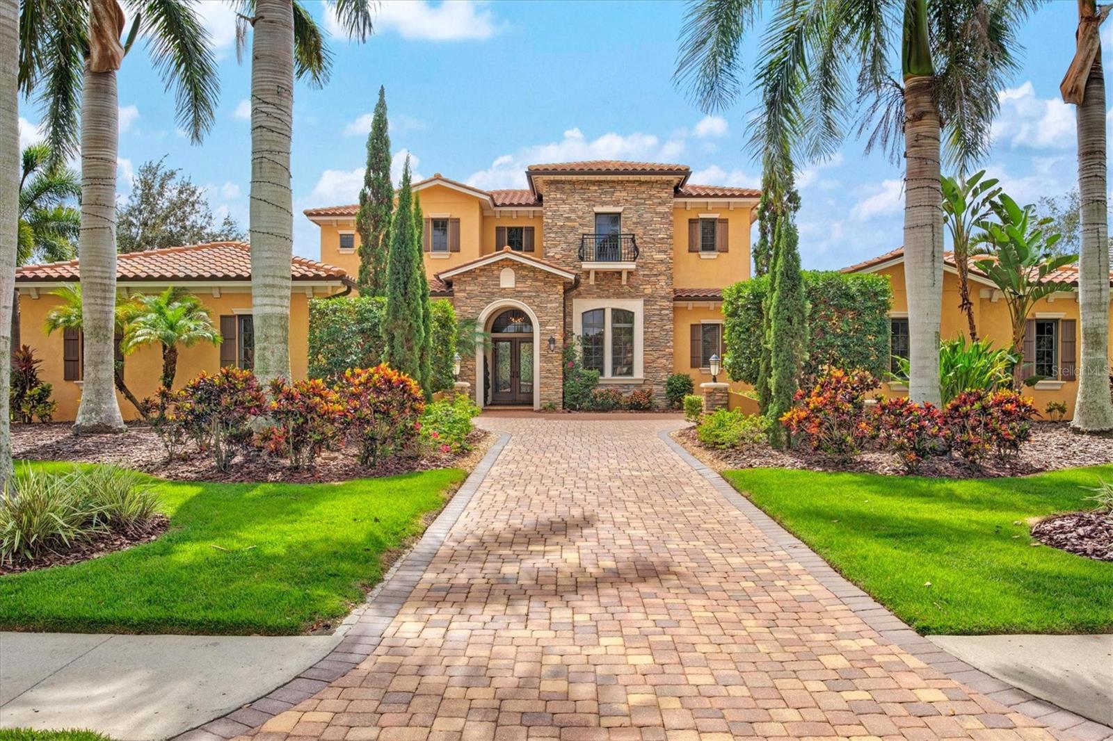 Nestled within  The Lake Club, an exclusive Tuscan-style, guard-gated community, is this custom home built by John Cannon, this custom-built residence is an embodiment of luxury. Beyond the guarded gates, a world of extravagance unfolds, inviting you to immerse yourself in the splendors of a half-acre haven that effortlessly merges with a serene lake, peaceful preserve, and a linear park . With six generously appointed bedrooms and six-and-a-half bathrooms, this home offers a lifestyle beyond compare. Double glass and wood front doors swing open, unveiling a world of aesthetic wonders. The grand family room takes center stage. Here, a gas stone fireplace, framed by custom-built shelving, stands as a masterpiece of craftsmanship. Architectural marvels continue with ceiling treatments, crown molding, and arched detailing. Enormous ten-foot sliding doors blur the line between indoor and outdoor living spaces. The kitchen is undoubtedly the heart of this home as it features granite countertops, stainless steel appliances, bespoke wood cabinetry, and a glass tile backsplash, dual Sub-Zero refrigerator and freezer, accompanied by a Wolf 48" four-burner double stove/griddle. Two generously sized pantries and an ice maker enhance the functionality of this epicurean haven. Adjacent to the kitchen, a spacious dining area, accentuated by substantial wall niches, opens onto the inviting lanai.
Retreat to the owner's sanctuary on the first floor with a sitting area invites you to relax, offering a tranquil escape from the demands of the day. The ensuite bath, adorned in marble, is a masterpiece of luxury, featuring dual sinks, a sumptuous garden tub, a vanity, and a walk-in dual shower. A capacious walk-in closet, complete with an island and built-ins, ensures that organization and storage are never a concern. Two additional closets and a storage area provide ample space for your wardrobe.
For outdoor enthusiasts, this residence presents an outdoor haven that rivals the interior in grandeur. An outdoor kitchen, equipped with a sink and grill, beckons you to unleash your culinary prowess in the open air. A saltwater heated pool and spa invite leisurely dips, while a cozy fireplace sets the stage for intimate gatherings under the stars. The Colonnade screened lanai, featuring two covered seating areas, is the perfect vantage point to soak in the beauty of the outdoors. Icynene insulation, water filtration, a water softener, hurricane-rated windows, CATV wiring, and a surround sound system enhance comfort and convenience. A fenced yard and a second laundry room located upstairs exemplify the meticulous attention to detail that has gone into creating this exceptional home. Residents of The Lake Club enjoy not only the privilege of residing in such an exceptional home but also access to the exclusive amenities of this distinguished community. The clubhouse, boasts a  dining room, a well-appointed bar, and versatile community spaces, including a pool table for leisurely entertainment. Step outside to discover two magnificent pools, a state-of-the-art fitness center, and pickleball and tennis courts for those with an active lifestyle. For families, there is a well-designed playground, a basketball court, outdoor fitness areas, and even two dedicated dog parks to ensure that every member of the family is catered to. This residence is a testament to uncompromising quality and thoughtful design. Seller is a licensed Realtor.