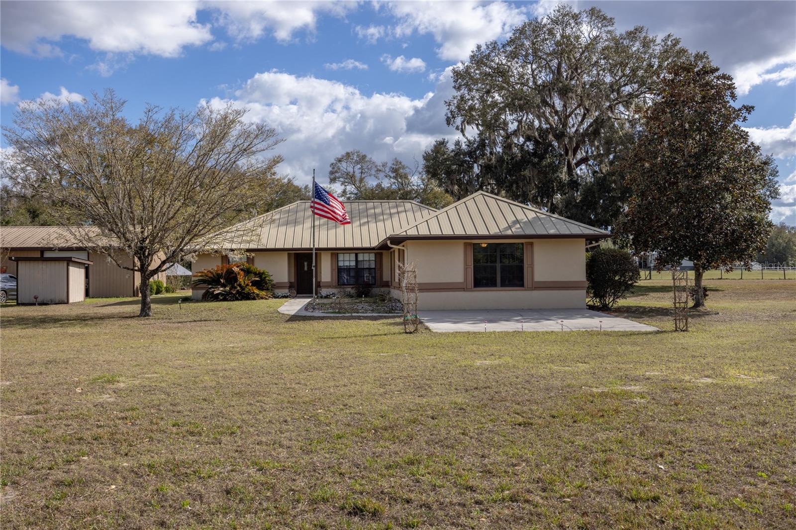 Welcome home to the beauty and charm of North Florida living. This well-maintained property offers space, versatility, and room to enjoy both indoor and outdoor living. Inside, you will find an open floor plan with vaulted ceilings in the main living room, creating a bright and spacious feel. A beautiful electric fireplace serves as the centerpiece of the main living area, adding warmth and character. The split floor plan provides separation between the primary bedroom and additional bedrooms, offering flexibility and privacy. The kitchen includes a separate pantry for additional storage, and the second family room provides extra living space that can be used as a home office, media room, hobby space, or whatever best suits your needs.

Step outside to enjoy the screened-in back porch, perfect for relaxing and taking in the peaceful surroundings. The fully fenced and cleared property offers plenty of room to spread out and enjoy outdoor living.

One of the standout features of this property is the incredible amount of additional space and functionality. The property includes a large 30x60 four-bay detached garage equipped with electricity and its own half bathroom, offering convenience for projects, storage, or hobbies. In addition, there is an 18x25 workshop and an 18x20 storage shed, both on concrete slabs with electricity, providing even more flexibility for equipment, tools, or additional workspace.

The home also features a brand new water softener system, adding to the overall comfort and efficiency of the property.

With no HOA and no deed restrictions, this property offers flexibility and freedom while still providing a comfortable place to call home. With an open layout, multiple living areas, extensive outbuildings, and endless possibilities, this property is ready for you to enjoy everything North Florida living has to offer.