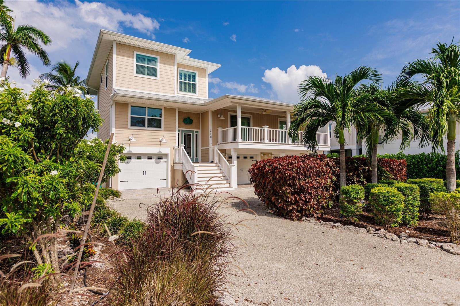 This spacious home is a prime Anna Maria north end location and overlooks Lake La Vista bayou with views to the Sunshine Skyway Bridge.  Over 5000 sf under roof including 2572 sf of elevated living area with 3 bedrooms and 3 full baths, 400 sf of covered balconies and patios, 3 garages and a bonus room with Enduraflood panels.  So much space for lots of waterfront living!!  Offered furnished, this home has an open floor plan, vaulted ceilings, crown molding and sliding doors showcasing the fabulous water views and relaxing balconies. Plenty of space for entertaining and large gatherings in the main living area.  The open kitchen has solid wood cabinets, granite countertops, colorful tile backsplash and a breakfast bar.  A separate office/laundry room is adjacent to the kitchen.  The huge third floor master bedroom has a private waterfront balcony, walk-in closet and large master bath.  Launch your boat, kayaks and paddle boards from the 40-foot composite dock with a 10,000 lb boat lift and fish table.  Plenty of storage and workspace for bikes, beach, fishing and hobby items.  There is room for a front yard pool or a cocktail spa on the waterfront side. Exterior renovations in 2016/2017 include metal roof, Royal Celect composite siding that never needs painting, Azek/Timber Tech balconies, decking and railings, hurricane rated PGT windows and doors, circular driveway and low maintenance landscaping.  This lovely, single-family residence can be converted to a vacation home with short term rentals permitted. Photos were taken prior to hurricanes, some landscaping and furnishings have changed.
