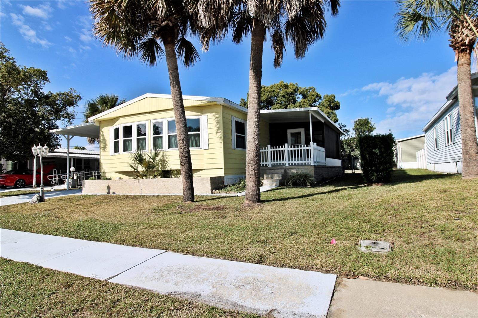 One or more photo(s) has been virtually staged. Well-maintained 2-bedroom and 2-bathroom double-wide in Laurelwood Mobile Estates, a quiet 55+ community in Port Orange. YOU OWN THE LAND.  NO LOT RENT.  Spacious 1,392 SF living area on a landscaped lot with private irrigation well/pump. Upgrades include 2023 HVAC, 2017 roof, and 2014 windows. Interior features vinyl flooring, ceiling fans, kitchen island, pantry, wet bar, and inside laundry. Primary suite includes walk-in closet and en-suite bathroom.  Exterior highlights include screened patio, carport, and extra storage.  No rentals allowed (except grandfathered owners). Optional HOA ($25/year) supports signage and lighting, and administrative costs. Located near Port Orange PD and Water Treatment Plant - helps prevent power outages during storms. Close to shopping, dining, and medical.