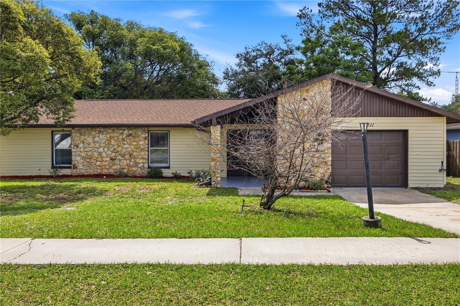 Welcome home to this move-in ready 3-bedroom, 2-bath residence located in the SW area of Ocala! This home is the perfect startup or investment property. The natural stone accents and covered foyer entry gives this home great curb appeal.  Step inside to a brightly lit floorplan featuring luxury vinyl flooring throughout. The spacious living area gives way to the dining area while the sliding glass doors lead out to the enclosed covered patio which is the perfect place to unwind, entertain your family and friends or just enjoy those comfortable Florida evenings year-round. The large galley kitchen includes stainless appliances, an abundance of cabinets and a double sink for ease of cleanup after a great family meal.  The primary suite offers a restful retreat complete with a walk-in closet, an updated bathroom featuring a shower/tub combo plus there is a  private sliding glass door leading directly to the backyard.  Outside, enjoy a full privacy fenced backyard offering plenty of room for pets, play, or get together. The oversized garage makes the perfect craft room, man cave or she shed, let your imagination run wild! Minutes away from shopping, dining, entertainment, and major highways, this home combines comfort and an unbeatable location.