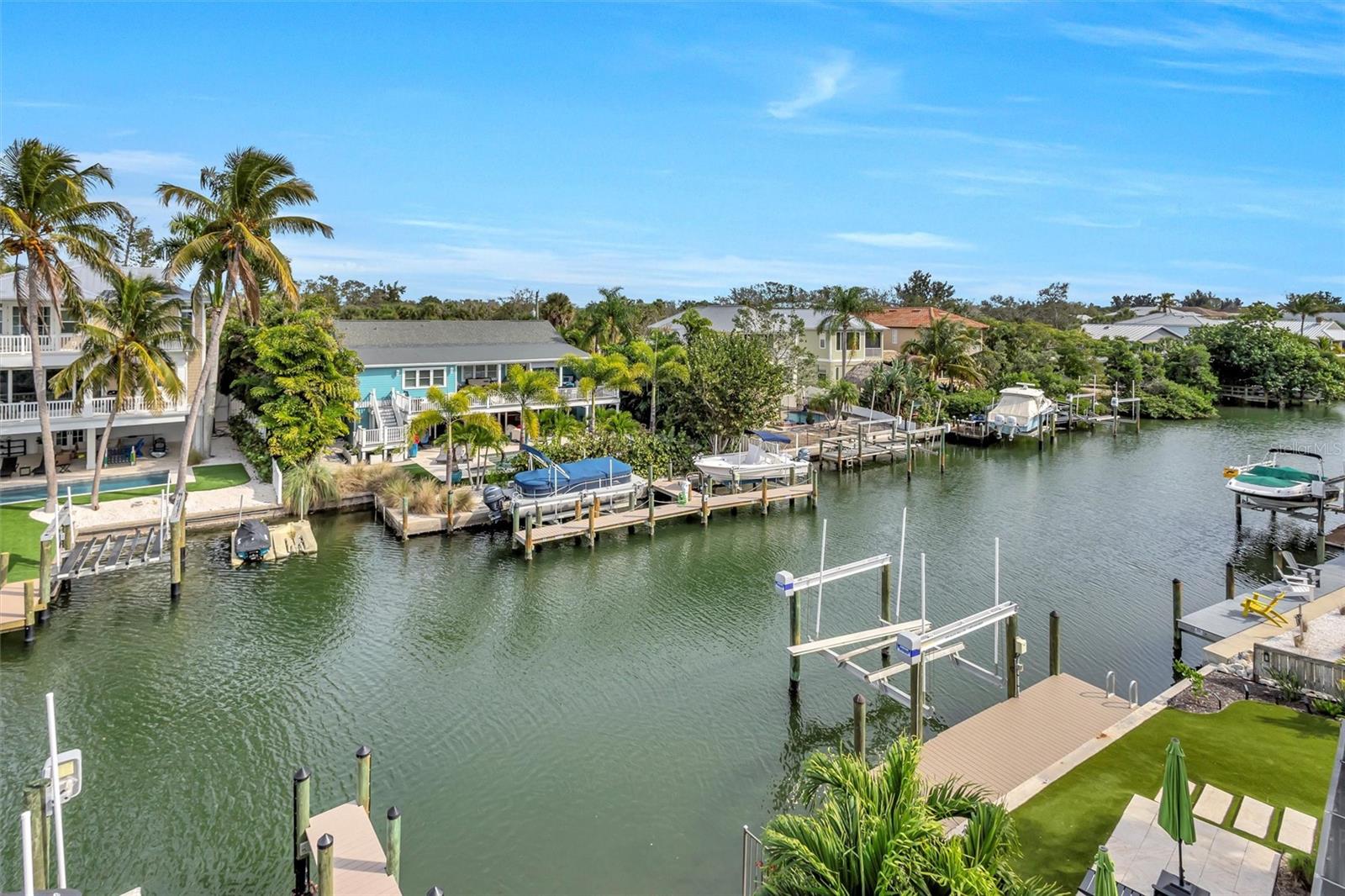 Why wait to build an elevated home? Here is your chance to have a modern coastal retreat on Siesta Key’s Grand Canal — beautifully designed, impeccably finished, and perfectly positioned for the ultimate waterfront lifestyle. This exceptional 2020 built three-story residence combines luxury, comfort, and an effortless indoor–outdoor flow, all just moments from Siesta Key Village. From the moment you step inside, wide water views draw you through the home, highlighting the sparkling canal, private dock, jet-ski or boat lift, and the ideal boating water that makes this property so special. The interior is bright, open, and meticulously curated with a relaxed, coastal-chic aesthetic. A sleek private elevator services all floors, while oversized sliders open to multiple balconies and terraces, each framing postcard-perfect views. The main living level features an expansive great room with tray ceilings, abundant natural light, and entertaining-friendly open floorplan, including a dining area with balcony—perfect for morning coffee or sunset cocktails. The chef’s kitchen is a showpiece, offering custom cabinetry, premium stainless appliances including a gas convection Bosch range, a massive island with storage on all sides, designer pendant lighting, and gorgeous stone countertops. Whether you’re prepping a feast or entertaining friends, the space is both functional and stunning. The bedroom accommodations are thoughtfully designed for both comfort and flexibility. On the main living level, a beautifully finished guest bedroom with adjacent full bath provides the perfect space for visitors or a sophisticated home office. The primary suite is a true retreat, offering a private balcony with sweeping canal views and a spa-inspired bath featuring a soaking tub, glass-enclosed walk-in shower, refined tilework, and dual stone-topped vanities. Two additional guest bedrooms, each with custom closet built-ins, are positioned at the end of the hall, while a bright and spacious laundry room adds everyday ease to this well-planned level. Outdoors, the covered lounge area is pure relaxation, featuring a beautifully finished wood ceiling, comfortable seating, and a shimmering pool that sits just steps from the water. An outdoor shower adds a resort-like touch, making it easy to rinse off after boating, paddleboarding, kayaking, or swimming. Hurricane rated, higher elevation, newer seawall...all of the boxes are checked for peace of mind living. This home has held strong through past storms with no water entering the interior living areas. The waterfront lifestyle here is unmatched: • Deep, protected Grand Canal waterway • Private dock with a 10,000 lb lift, which could accommodate a nice size boat or a pair of jet skis • Easy boating access to the Intracoastal Waterway • Perfect setup with ladder for kayaking, paddleboarding & jet-skiing • Multiple balconies with panoramic water views • Elevator to all levels • Stylish, high-end finishes throughout • New pool heater and pool pump in 2024. This home delivers the best of Siesta Key: a quiet, peaceful waterfront cul-de-sac setting with unbeatable boating water—yet close enough to stroll, bike, or golf-cart to the Village for dining, shopping, live music, and dancing. This home even includes the SK local favorite Tube Dude unique mailbox! It’s coastal luxury, modern design, and island adventure all wrapped into one exceptional property. This home is spotless! Truly a great find for a move-in ready beach home.