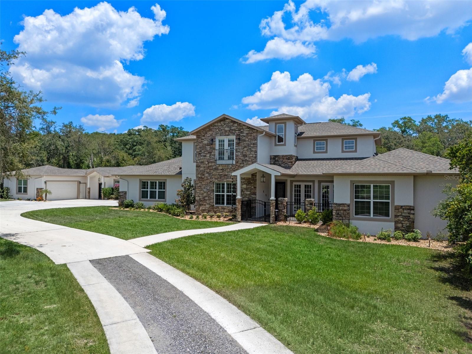Welcome to Your Dream Estate in the Scenic Sugarloaf Mountain Area!

This exceptional multi-generational custom-built estate is nestled on 5.27 acres of beautifully landscaped property framed by majestic oak trees. Freshly painted and packed with luxury features, this home is designed for comfort, entertainment, and long-term living.

The main residence boasts four spacious bedrooms, five full bathrooms, one half bath, and a three-car garage. At the heart of the home is a chef’s dream kitchen featuring custom wood cabinetry, a built-in oven and microwave, gas cooktop, massive island, and high-end stainless steel appliances. The soaring 20-foot ceilings in the living room are complemented by exposed wood beams, a retractable chandelier, stone accent wall, and a cozy electric fireplace—all creating a warm and elegant atmosphere.

The primary suite opens directly to the pool lanai and includes a spa-like en-suite with dual vanities, a luxurious rain shower, and dual walk-in closets. The custom laundry room is equally impressive with extensive cabinetry, a farmhouse sink, second dishwasher, and premium washer and dryer.

Step outside to your own private resort-style oasis featuring a custom saltwater pool with spa, covered lanai, and a fully equipped outdoor kitchen with a grill, pizza oven, sink, and bar seating. A full bathroom is conveniently located on the pool deck.

For entertainment and relaxation, enjoy two axe-throwing stations, a regulation horseshoe pit, and a wood-burning fire pit area surrounded by custom pavers and ambient lighting.

The in-law guesthouse offers incredible versatility with two additional bedrooms, two and a half bathrooms, laundry, two large bonus rooms, and a two-car garage. Its beautifully designed kitchen includes a gas range, farmhouse sink, and abundant  cabinetry. Ideal for extended family or long-term guests.

Additional upgrades include: Solar panels (owned),  Plantation shutters, Luxury finishes throughout

This is the perfect estate for multi-generational living or those who simply want room to spread out in style and comfort.

Don’t miss this rare opportunity!
Ask your Realtor for the Feature List, Floor Plan, 360° Virtual Tour, and Video Tour today.