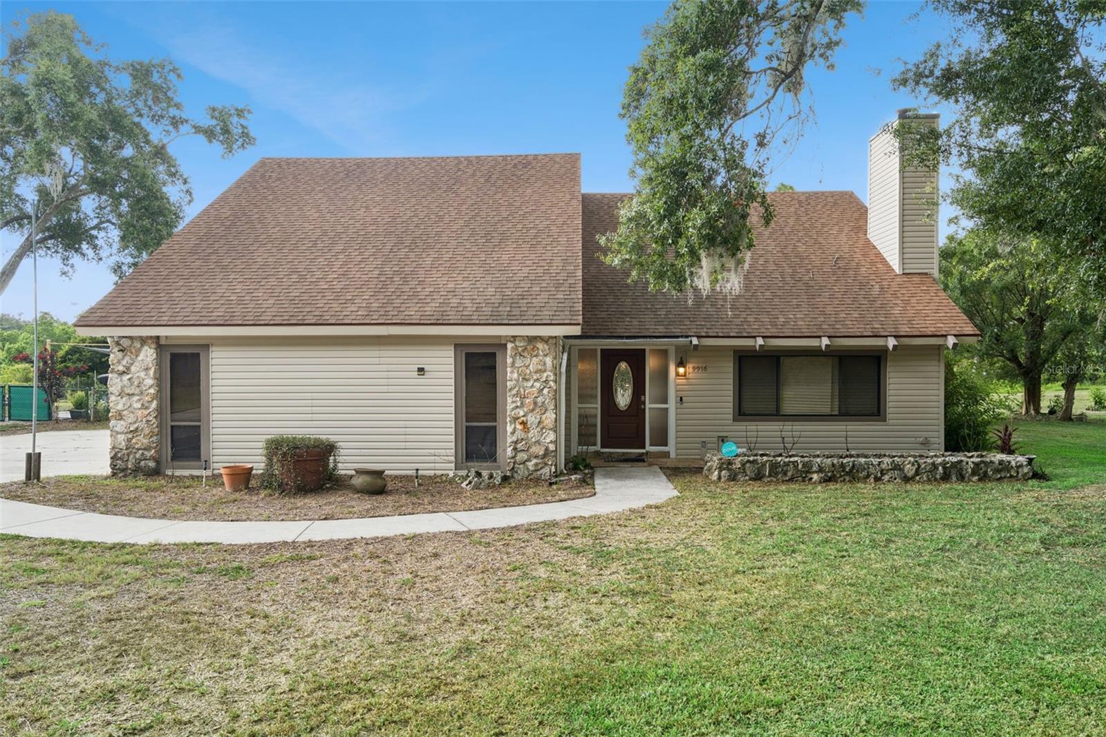 POOL HOME ON NEARLY HALF AN ACRE WITH NO HOA! Welcome to this spacious 3-bedroom, 2.5-bath Leesburg home offering 2,496 heated square feet, a private in-ground pool, attached 2-car garage, downstairs primary bedroom, formal dining room, interior laundry room, and a large upstairs loft. The living room features vaulted ceilings, exposed wood beams, and a stone wood-burning fireplace, creating a warm central gathering space. The kitchen offers granite-look counters, a breakfast nook, range, microwave, refrigerator, and dishwasher. Enjoy multiple outdoor living areas, including a covered rear patio, screened upper porch, poolside gazebo, storage shed, fenced yard, mature trees, and peaceful pond views. Conveniently located near US-441, shopping, dining, downtown Leesburg, and area amenities.