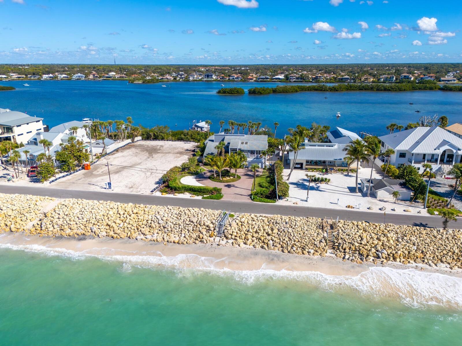 Experience true Florida coastal living in this impeccably maintained Key West–style home on Casey Key, offering the rare and coveted Gulf-to-Bay lifestyle. Thoughtfully designed with high ceilings and a bright, open feel, this residence blends relaxed island charm with modern updates throughout.  Step outside to a beautifully landscaped, fenced, and gated backyard—your own private oasis. Enjoy the Pebble Tec resurfaced pool, perfect for entertaining or unwinding after a day on the water. Boaters will love the new composite dock with covered lift, providing effortless access to the bay and Gulf beyond.  The dune walkover and 100 feet of private sandy beachfront is perfect for afternoons by the shore and evening sunsets.  Adding exceptional flexibility, the separate guest house features one bath and two bedrooms (or one bedroom plus a den)—ideal for guests, extended family, or a home office retreat.  This home has been extensively updated for peace of mind, including hurricane shutters, newer HVAC systems, water heaters, well pump, and a whole-house replumb. Every detail reflects pride of ownership and careful maintenance.  Whether you’re seeking a full-time residence or a luxurious island escape, this exceptional Casey Key property delivers privacy, comfort, and the ultimate waterfront lifestyle.