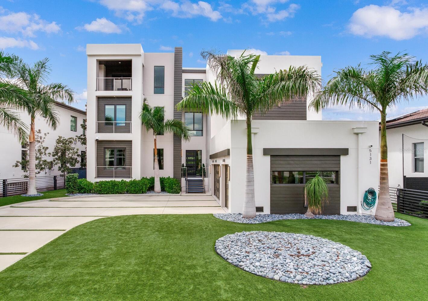 Breathtaking Three-Story Waterfront Sanctuary in South Tampa
Step into 5131 Neptune Way, a dramatic Malibu Modern waterfront masterpiece where sunlight dances through expansive windows, highlighting soaring ceilings and open, flowing spaces. Every room is meticulously designed, offering panoramic water views that create a serene and luxurious atmosphere throughout this 6,520 sq. ft. estate. With 6 generously sized bedrooms, 6 full bathrooms, a private office, state-of-the-art movie theater, personal gym, elevator, and an oversized 3-car garage, this home is as functional as it is breathtaking.
The first floor welcomes you with a mudroom, walk-in pantry, gourmet kitchen, dining room, living room, den, a large bedroom and a full bath, offering thoughtful spaces for both daily life and hosting. On the second floor, a spacious loft, laundry room, three bedrooms with full en-suite baths, and a state-of-the-art theater creates a versatile and comfortable family retreat. The third floor is designed for wellness and entertainment, featuring a gym, sauna, two bedrooms with a full bath, a large open entertainment area and an office. There is access to the terrace, an expansive outdoor sanctuary unto itself, complete with a gorgeous fire pit; perfect for entertaining or savoring serene waterfront sunsets.
The gourmet kitchen, a true chef’s dream, showcases custom cabinetry by Allikristé, premium Wolf appliances, a massive island, and a 200+ bottle wine cellar, perfect for intimate family meals or entertainment on a grand scale. Open concept living areas flow seamlessly to outdoor spaces, including an infinity pool and spa, summer kitchen with 40” grill and wet bar, a fire pit, and private boat dock with lift (10,000 lbs.), ensuring that every moment is spent in uninterrupted waterfront bliss.
Nestled in the Beach Park neighborhood, this home offers unparalleled privacy, elegance, and convenience, minutes from Tampa International Airport, Bayshore Boulevard, Hyde Park, Sparkman Wharf, top-rated schools, and St. Pete/Clearwater beaches.
5131 Neptune Way is not just a residence, it is an extraordinary lifestyle, combining sophisticated design, open airy spaces, and the ultimate in waterfront luxury.