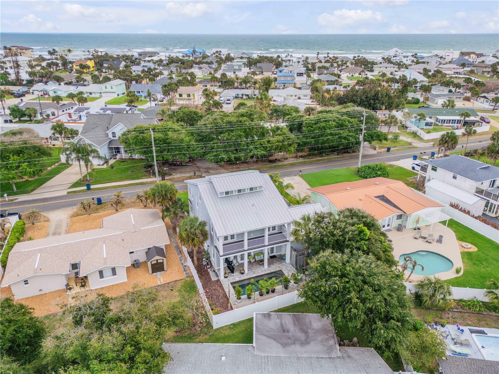 Built in 2019 by Brent Walters, this custom-crafted and impeccably maintained 4-bedroom, 2.5-bath beachside pool home offers a blend of refined design, privacy, and coastal charm, just steps to the ocean. Filled with natural light, this residence lives like a private retreat. The open-concept main living area flows effortlessly, featuring a chef-inspired kitchen with solid surface countertops, stainless steel appliances, a generous breakfast island, and stylish finishes are perfect for both entertaining and everyday living. Spacious living areas provide plenty of room to gather with family and friends. The spacious primary suite has a private balcony to enjoy the coastal breezes. The ensuite bath is thoughtfully designed with a freestanding soaking tub, a large walk-in shower with floor-to-ceiling tile, and elegant finishes throughout. The additional bedrooms share a well-appointed Jack-and-Jill bathroom. The third-floor landing offers a versatile flex space ideal as a 4th bedroom for a home office, reading nook, or creative retreat. Step outside to your own private oasis, complete with a sparkling saltwater pool and outdoor shower, perfect for relaxing after a day at the beach. Additional highlights include a 2-car garage, a whole-home Generac Generator, and well-designed indoor-outdoor living spaces. Located in the desirable Silver Sands beachside community of New Smyrna Beach, this home offers convenient beach access and a laid-back coastal lifestyle. Whether you're seeking a primary residence, vacation home, or investment opportunity, this property delivers exceptional comfort, location, and appeal. Schedule your private showing today.