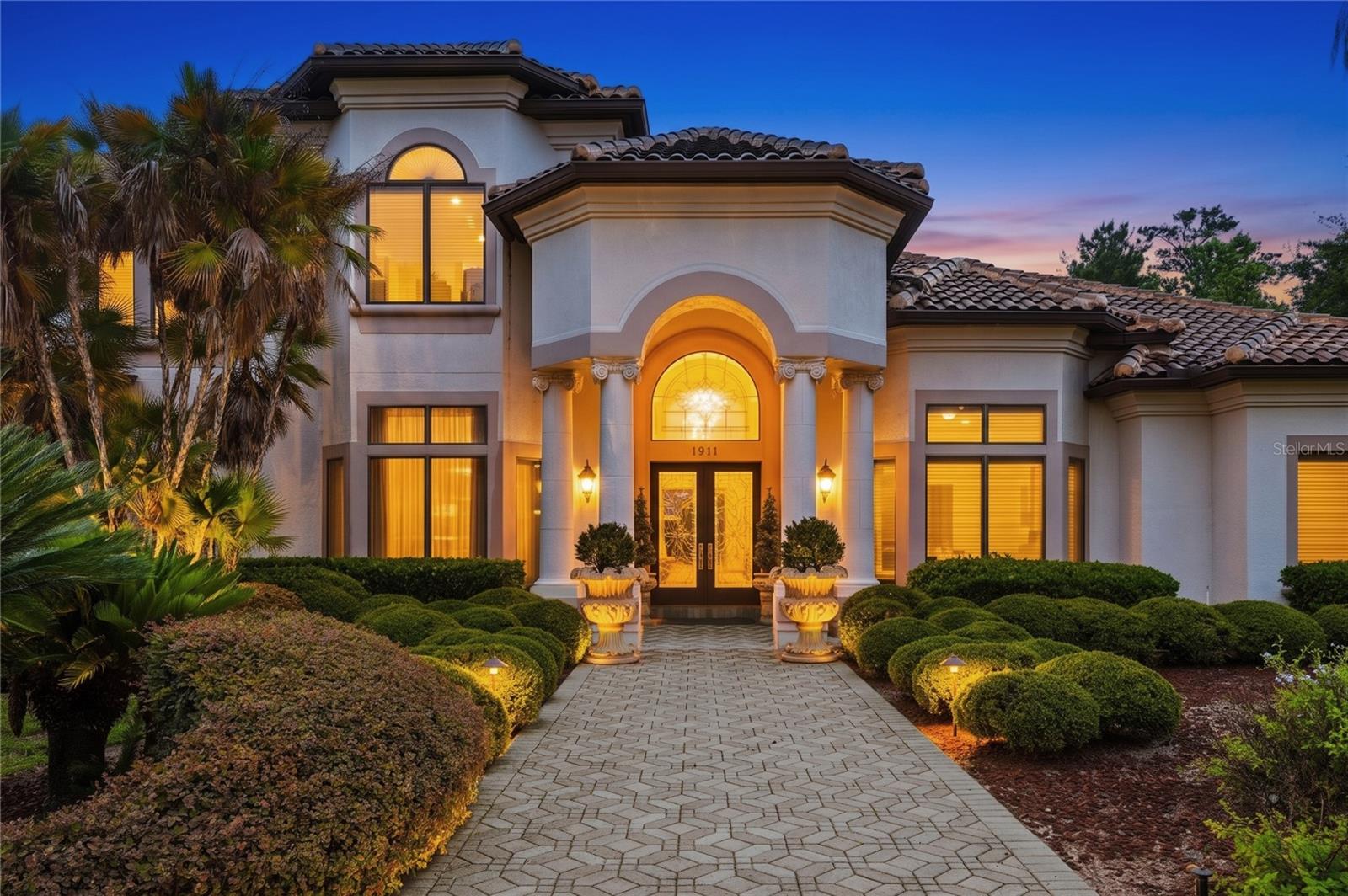 Welcome to a rare offering in the enclave of Heathrow Woods, where timeless elegance, architectural grandeur, and resort-inspired living converge in one extraordinary estate.

Offered for the first time since its construction, this magnificent custom residence, crafted by renowned luxury builder Howard Pomp of First Southern Homes, encompasses over 8,000 square feet of impeccably designed living space. Perfectly positioned on a private homesite surrounded by lush wooded views, this exceptional estate offers 5 bedrooms, 5 full baths, 2 half baths, an executive office, billiards room, and private theater, creating a lifestyle reserved for the most discerning buyer.

From the moment you enter, a sense of refinement and grandeur unfolds. Soaring ceilings, rich marble flooring, intricate millwork, and exquisite architectural detailing create a dramatic yet welcoming atmosphere. Every room has been thoughtfully designed to showcase superior craftsmanship and elegant proportions.

The formal dining room is a true showpiece, highlighted by an extraordinary custom wood-inlaid ceiling adorned with intricate floral detailing and framed by stately columns, creating a setting worthy of the most elegant gatherings. The formal living room captures stunning views of the resort-style pool through graceful arched windows and French doors, seamlessly blending indoor and outdoor living.

The distinguished executive office rivals those found in luxury estates and private libraries, featuring floor-to-ceiling custom bookcases complete with a rolling library ladder, creating an inspiring space for work, study, or reflection.

Designed for both grand entertaining and everyday luxury, the gourmet chef's kitchen is a masterpiece. Anchored by a striking Galaxy Black granite island, the space showcases exquisite custom cabinetry, premium appliances, a fully equipped butler's pantry, and an elegant beverage bar designed for effortless hosting. The kitchen flows seamlessly into the spectacular family room, where an imported cast-stone fireplace, custom built-ins, and soaring two-story ceilings create an atmosphere of warmth and sophistication. Above, a dramatic second-floor gallery overlooks the space, adding to the home's architectural significance.

The first-floor primary suite serves as a private sanctuary of exceptional scale and luxury. Spacious custom-designed walk-in closets and a spa-inspired bath create a retreat that rivals the finest luxury resorts. Floor-to-ceiling stone and tile finishes, elegant custom cabinetry, designer fixtures, and a lavish walk-in shower combine to create an environment of tranquility and indulgence.

Upstairs, a second primary suite offers the perfect private wing for guests or multi-generational living, complete with its own sitting area, generous walk-in closet, and beautifully appointed en-suite bath featuring a frameless glass shower, custom vanity, designer finishes, and refined details that mirror the quality found throughout the estate.

The crown jewel of the property is the breathtaking outdoor living environment. The expansive screened lanai surrounds a spectacular resort-style pool and spa, creating a private oasis that feels worlds away. Lush tropical landscaping, integrated greenery, multiple lounging and entertaining areas, and serene views from nearly every room create an atmosphere reminiscent of an exclusive luxury resort.