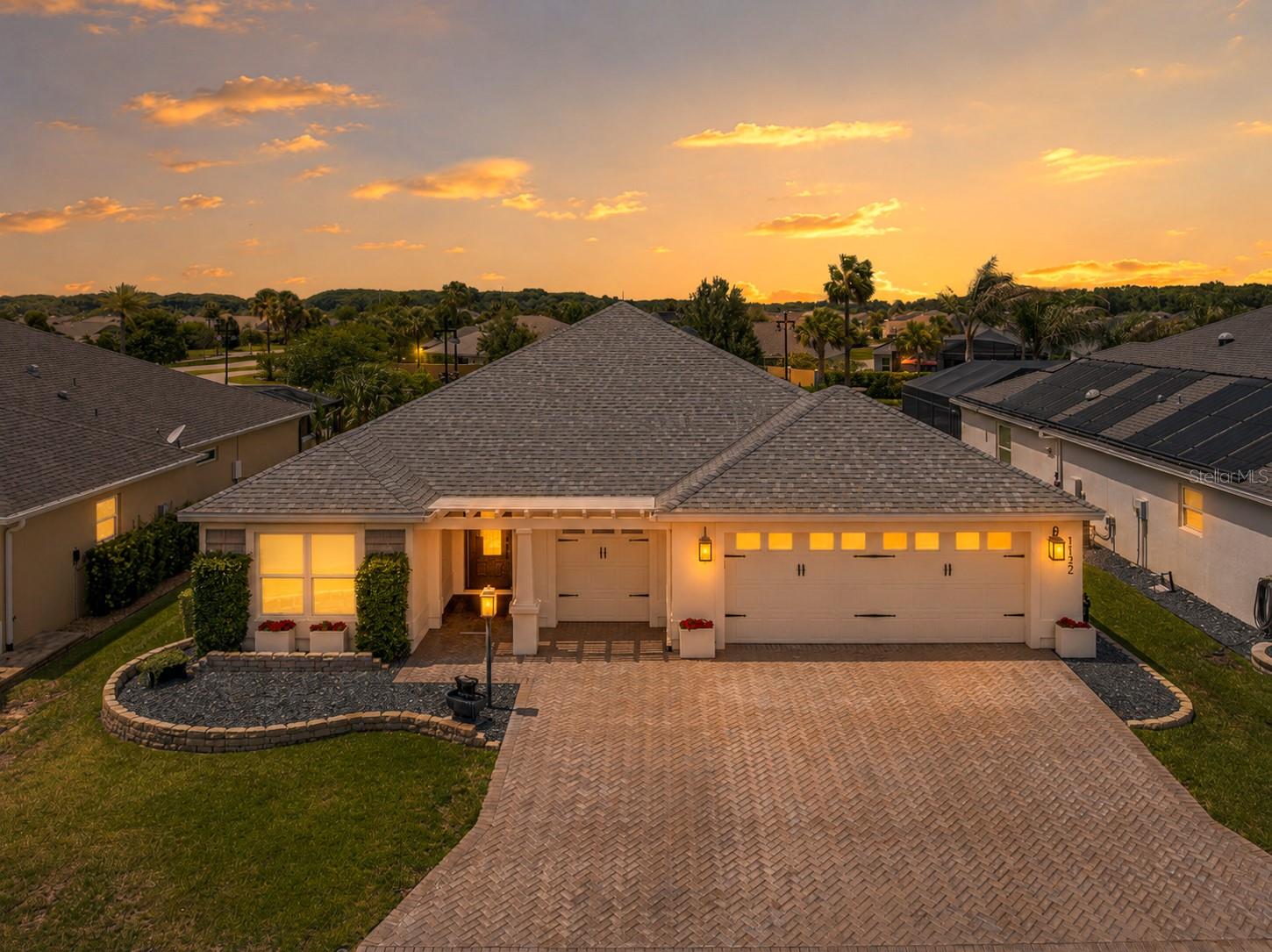 Welcome to one of the most distinctive homes in The Villages. This exquisitely renovated EXPANDED DESIGNER INDIGO MODEL in the highly sought-after VILLAGE OF BRADFORD seamlessly blends the timeless charm of a European-inspired cottage with the sophistication of a custom designer residence.

From the moment you arrive, you'll be captivated by the stately OVERSIZED herringbone brick-paver driveway leading to an EXPANDED two-car garage plus golf cart garage, offering room for two cars and two golf carts. Decorative flower boxes, custom shutter accents, jasmine-covered trellises, stacked-stone landscape walls, and lush mature plantings create extraordinary curb appeal and set the tone for what awaits inside.

Thoughtfully reimagined from top to bottom, this 3-BEDROOM, 3-FULL BATH home showcases exceptional craftsmanship and attention to detail throughout. The open-concept floor plan features upgraded neutral ivory tile flooring in the main living areas, luxury vinyl plank flooring in the bedrooms, custom millwork, beadboard accents, portrait rail molding, enhanced baseboards, custom window trim, and a striking neutral color palette of warm French creams and beige tones.

The stunning designer kitchen serves as the heart of the home and is truly a work of art. Anchored by a striking custom brick feature wall and bespoke range hood, it offers quartz countertops, shaker cabinetry, pendant lighting, all-new high-end glass-front appliances, designer sinks, imported hand-cast hardware from the United Kingdom, custom millwork, and upgraded electrical features. The adjoining laundry room has been transformed into an elegant BUTLERS PANTRY complete with additional cabinetry, custom spice shelving, hand-forged gallery rails, brass shelf hardware, and a deep matte finish sink.

The luxurious primary suite has been elevated to an entirely new level, featuring extensive custom finishes and a beautifully redesigned ensuite bath. A second primary suite provides exceptional comfort and privacy for family and guests, while the third bedroom and bath continue the home's theme of thoughtful design and refined finishes.

Step outside to your private backyard retreat, where a custom-designed lanai with two-tone tumbled-stone pavers, new ceiling fans, and upgraded lighting overlooks a tranquil European courtyard-inspired garden. Surrounded by stacked-stone walls, fragrant jasmine, mature holly trees, lush landscaping, a vintage fountain, wood-burning fire pit, and a privacy wall, this enchanting outdoor space offers complete seclusion for relaxation and entertaining. There is also plenty of room for a pool.

Even the OVERSIZED garage is a showpiece, featuring custom millwork and a premium showroom-quality Rust-Oleum RockSolid epoxy floor coating. The expanded design easily accommodates multiple vehicles and golf carts while providing abundant storage space.

Freshly painted inside and out and loaded with upgrades too numerous to list, this one-of-a-kind home offers a rare combination of luxury, character, craftsmanship, and comfort. Ideally located near Sawgrass Grove, Eastport, Brownwood Paddock Square, golf, recreation, dining, and shopping, this remarkable property is truly unlike anything else on the market.

This is more than a home, it's a lifestyle, a retreat, and a place you'll fall in love with the moment you arrive. Call us for your private tour.