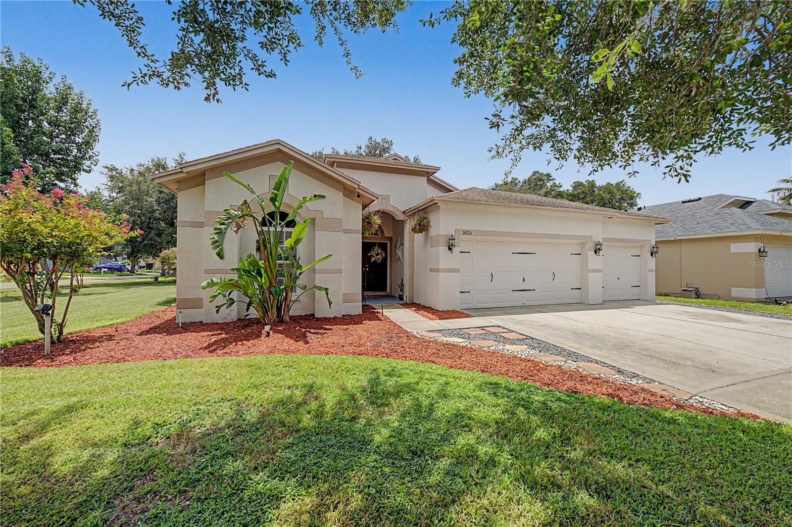LUSH LAKE BERNADETTE LOT welcome you HOME to this immaculate, move-in-ready four-bedroom, two-bath home located in this established golf course community! From the moment you enter through the welcoming foyer, you'll appreciate the spacious open-concept design that effortlessly connects the great room, gourmet kitchen and an expansive Florida room through sliding glass doors... creating the ideal setting for entertaining, family gatherings, or simply enjoying Florida's year-round lifestylle. The beautifully updated kitchen is the heart of the home, complete with stunning quartz countertops, stainless steel appliances, a stylish backsplash, a functional center island, and a sunny breakfast nook. A versatile formal dining room, currently used as a cozy lounge, showcases custom built-in cabinetry, providing both elegance and additional storage. The thoughtfully designed split-bedroom floor plan offers privacy for the luxurious primary suite, featuring dual vanities, a built-in makeup station, a relaxing garden tub, separate walk-in shower, and dual walk-in closets. Secondary bedrooms and full bathroom are located on a separate wing for privacy.  Situated on an oversized corner lot, the fully fenced backyard is your own private retreat with plenty of room to play, garden, or entertain. Gather around the gas fire pit on cool evenings, cultivate your favorite flowers or vegetables in raised garden beds, or unwind on the open patio with your morning coffee or evening beverage. Additional highlights include a spacious three-car garage, security system, abundant storage throughout, and a conveniently located laundry room near the guest bedrooms. Residents of Lake Bernadette enjoy a low quarterly HOA with exceptional amenities, including a clubhouse, fitness center with showers, two community pools, playground, lighted tennis and basketball courts, satellite TV, and a full calendar of planned social activities, while golf membership is available separately. Ideally located just minutes from both Zephyrhills and Wesley Chapel, with convenient access to major highways, shopping, dining, healthcare, and entertainment, this exceptional home truly has it all. CALL today and experience everything this beautiful property has to offer!