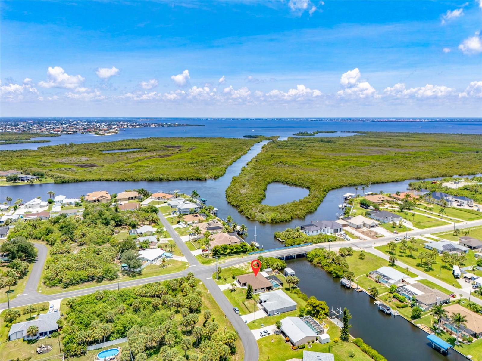 This PRIME SALT WATERFRONT home gives you EXCEPTIONALLY QUICK GULF ACCESS and features a beautifully renovated 3 bedroom, 2 bathroom, 2 car garage layout with 90 feet of frontage on the scenic Ackerman Waterway. This fantastic property boasts wonderful curb appeal with a chain linked fenced yard, Bahama shutters, and stylish stone accents. Inside, the spacious living and dining areas are enhanced by decorator fans and oversized tile flooring throughout, creating a wonderfully inviting atmosphere. The well appointed kitchen is equipped with new, modern appliances, granite countertops, a tile backsplash, recessed ceiling with overhead fan, and abundant cabinetry, including a convenient pass through to a long breakfast bar that magically overlooks the pool and waterway, a large den and dining area ideal for both entertaining and everyday dining. The spacious primary bedroom offers private patio and pool access, serene water views, a large closet, and its own ensuite bath, while this split floor plan also provides two guest bedrooms featuring detailed closets and shiplap ceilings that add warmth and a sensational coastal vibe. They may never want to go back home after visiting here! CITY WATER AND CITY SEWER! The heart of the home is the outdoor space, centered around a sparkling HEATED SALTWATER POOL with maximum visibility PANORAMIC PICTURE FRAME SCREENS for year round enjoyment, multiple covered areas for relaxing, a large roll-up door shed, a covered boat lift, and an extra-long 29' boat dock with water perfect for fishing right from your backyard. Additional highlights that add value and convenience include city water, NEW ROOF 2022, NEW DUCTWORK AND AIR CONDITIONING 2021, an updated 200 AMP ELECTRICAL PANEL, a NEW POOL HEATER 2024 and NEW POOL CAGE, NEW APPLIANCES 2025, with NO HOA or NO DEED RESTRICTIONS. Unwind where every day is a vacation right here at home as this is coastal living at its finest. Just minutes from Port Charlotte Beach, a favorite biking destination with a boat ramp, bocce and horseshoe pits, tennis courts, volleyball, playgrounds, a boardwalk, fishing pier, picnic pavilions, a rec center, and dog friendly areas, all set against jaw dropping sunsets! Close to historic downtown Punta Gorda, the luxurious Sunseeker Resort, dining, farmers markets, festivals, Punta Gorda Airport, shopping, and so much more, this INSTANT GULF ACCESS home with stunning saltwater lake views promises a lifestyle of relaxation and endless enjoyment. Don’t miss out on this extraordinary opportunity! SCHEDULE YOUR PRIVATE TOUR TODAY and start living your dream!