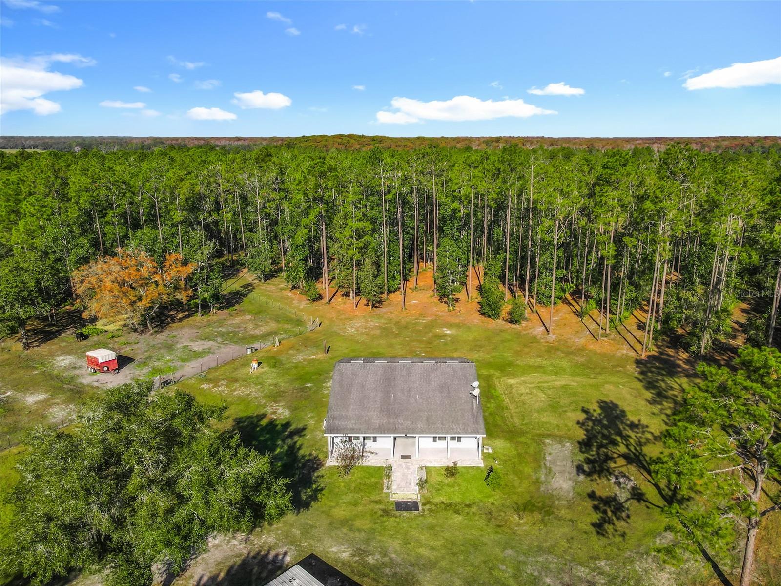Looking for privacy, peace, and quiet? This beautiful 10-acre property—featuring a custom-designed solid block 3-bedroom, 3.5-bath home—offers the serenity and space you’ve been dreaming of. Step inside to a fantastic, efficient floor plan with no wasted space. The open-concept Great Room flows seamlessly into the spacious kitchen, creating the perfect setting for entertaining or gathering with family. The kitchen features solid wood 42-inch cabinetry, a large island, and abundant counter space. A large laundry/utility room is located beside the kitchen for storage and wash. Expansive windows throughout keep the home bright while providing sweeping views of your private acreage. The split bedroom layout includes a generous Primary Suite with a walk-in closet and an en suite bathroom complete with dual sinks and an oversized walk-in shower. Each of the two large secondary bedrooms also offers its own private full bath and ample closet space—an ideal setup for multi-generational living or long-term guests. A convenient guest half bath is located off the main living area. French doors open to the impressive 44' x 15' screened lanai, spanning the entire back of the home. Enjoy peaceful mornings and evenings watching native wildlife—deer, hawks, and more—right from your own backyard. The property and home is offered as a 10 acre, high-and-dry parcel to be split from the current 20 acre homesite listed at 800k as MLS o6363085. It includes a 1-acre fenced pen currently used for cows, plus three pole barns—one 60' x 30' and two 30' x 15'—providing exceptional versatility. Timber, yellow pine planted offers beautiful private forest and agricultural tax advantage or ready to be harvested for value if cut to clear more of the property. There is a small pond on the property. Bring your horses and enjoy nearby riding trails at Lake Heart Conservation Area. Location is a dream for equestrians: • Heart Island Conservation with 5 miles of horseback riding trails is located at the end of Winning Wood Trail • Ocala National Forest with over 100 miles of looping horse trails is 30-minutes • Spring Garden Ranch, North America’s largest Standardbred training facility, is only 4 miles away • Rocking Horse Stables, a USEA-recognized event venue for dressage, jumping, and cross-country, is 28 miles away • The world-renowned Ocala World Equestrian Center is just 60 miles from the property All of this is conveniently located minutes from DeLeon Springs State Park, offering swimming, birdwatching, and dining at the historic Sugar Mill Pancake House. You’re also just 32 miles from Daytona Beach and a short drive to charming downtown DeLand, known for its Old Florida character with modern amenities. Daytona Beach International Airport 29 miles. A This exceptional property combines privacy, nature, and true Florida living—a rare opportunity you won’t want to miss.