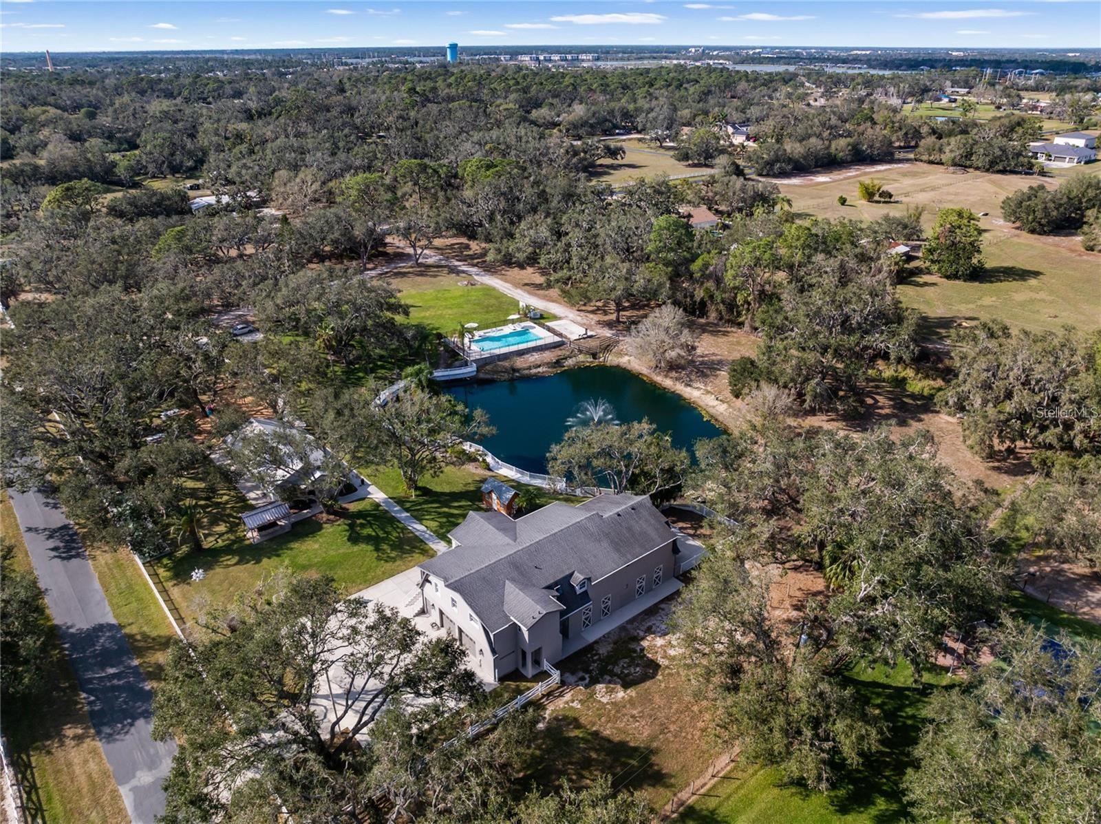 Under contract-accepting backup offers. Discover the Ultimate Sanctuary in Fox Creek II! Tucked away on a private drive, this breathtaking 5-acre estate—one of the last remaining in Sarasota where you can build your dream home—offers endless opportunities. Whether you’re looking for a private family compound, a horse lover’s paradise, a premier event venue, or the perfect place to run your business from home, this property has it all. Enclosed by lush trees and a solid perimeter wall, this magnificent estate is a true private oasis. Enjoy the oversized outdoor pool, explore the serene boating pond with its enchanting water feature, or let the little ones play in their own private playground. The entertainment hall, complete with a full kitchen, is the perfect space for unforgettable gatherings with family and friends. Currently an income-producing property, this estate has hosted private events, retreats, and gatherings, generating revenue as a sought-after venue. With endless possibilities, it can continue to serve as a profitable investment or be transformed into your dream residence. Enjoy the perfect blend of rural serenity and modern convenience. In just 5 minutes, you can access the interstate, opening a world of possibilities. The vibrant University Town Center (UTC) area—home to over 250 stores, top-tier restaurants, and entertainment venues—is only 12 minutes away. UTC also features Nathan Benderson Park, a world-class destination for outdoor recreation and international rowing events. Just 20 minutes away, Downtown Sarasota invites you to explore its rich arts scene, waterfront parks, and award-winning dining and only 30 minutes to the award winning Siesta Key Beach. This extraordinary 3-bedroom, 2-bathroom & space for optional 4th bedroom and 3rd bath with elevator estate isn’t just a home—it’s a private retreat where every day feels like a vacation. Whether you choose to enjoy its existing beauty, create the ultimate family compound, horse property, host spectacular events, or design and build your dream residence, the possibilities are truly endless. Don’t miss this rare opportunity—schedule your private showing today!