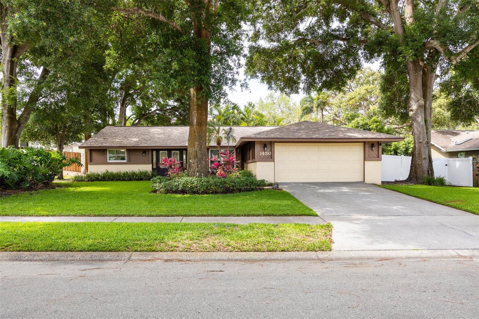 Welcome to 1430 Sutton Place Drive, a well-cared-for 3 BEDROOM, 2 BATH Palm Harbor home offering a comfortable split-bedroom floor plan, inviting indoor spaces and a backyard designed for the way Florida living is meant to be enjoyed…… Set in a quiet, low-traffic neighborhood with NO HOA, this home offers a practical combination of location, updates and everyday livability…… Inside, wood plank ceramic tile runs throughout the home, creating a clean, cohesive look that is both attractive and easy to maintain…… The living and dining areas flow comfortably together, offering flexible space for everyday living or casual entertaining…... The kitchen is neat, functional and centrally located, ready to use as-is while still offering the next owner an opportunity to personalize over time….. The PRIMARY SUITE is privately positioned and includes a spacious bedroom, a large walk-in closet with a CUSTOM STORAGE SYSTEM and a beautifully finished en-suite bath……. The secondary bedrooms are located on the opposite side of the home, giving guests, household members or home office needs welcome separation, and the second bathroom has also been tastefully updated…… OUTDOOR LIVING IS THE STAR HERE…… The screened saltwater chlorinated pool and detached spa area with retractable awning create a relaxing retreat for morning coffee, weekend gatherings or a quiet evening at home…. Beyond the pool, the backyard continues with your own putting green and a synthetic turf side yard, meaning there is no backyard grass to mow and more usable outdoor space to enjoy. Mature trees add shade and character, giving the backyard a relaxed, private feel…… Important updates include ROOF 2025, HVAC 2024, ELECTRIC PANEL 2025, WINDOWS 2010 and WATER HEATER 2013…... The location is another major advantage, with Palm Harbor University High School nearby, known for sought-after academic programs including International Baccalaureate and the Center for Wellness and Medical Professions. You are also close to Palm Harbor Middle School, historic downtown Palm Harbor, local restaurants, shops, the Pinellas Trail, Dunedin Causeway, Honeymoon Island and the Gulf beaches. Located in FLOOD ZONE X, where lenders do not require flood insurance it is also in a NON-EVACUATION ZONE…... Buyer should verify flood zone, evacuation zone, school assignments and insurance requirements…... Homes with this combination of Palm Harbor location, outdoor living, practical updates and NO HOA are not easy to find, so schedule your private showing today and see why this one is such a compelling opportunity.