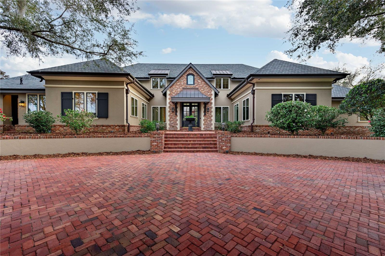 Discover the timeless elegance of this French country style home nestled on 3.6 acres of picturesque land in the exclusive “Estates” section of beautiful Lake Jovita Golf and Country Club. Arrive in style at this exquisite residence, where a grand first impression awaits with the meticulously crafted circular driveway setting the tone of luxury. As you pull up, a captivating water fountain greets you, creating a serene and elegant ambiance.  The Main house boasts five bedrooms, six and one half bathrooms, and over 8700 sq. ft. of conditioned living space that gives this residence a perfect blend of luxury and comfort. The elegant foyer leads you to the kitchen, a chef's dream, with windows overlooking Finger Bowl Lake and adorned with beautiful granite countertops, dual sinks, custom wood cabinets, Viking Professional appliances and walk-in wine cellar. Just off the kitchen is the butler’s pantry with dishwasher, Viking oven and refrigerator/freezer. Step into the epitome of spacious elegance in the family room with grand 20-foot high cathedral ceilings adorned with exposed beams. The room exudes warmth and charm with a large fireplace, creating a focal point that invites gatherings and cozy moments. Adding to the allure, balconies from the second floor provide a captivating vantage point, allowing family members and guests to overlook the inviting expanse below. With a perfect blend of architectural magnificence and comfort, this family room is a sanctuary where cherished memories are created.
The master suite greets you with a coffered ceiling and custom mill work, wet bar, and French doors leading out to a private patio. Separate his and hers en suite bathrooms compliment the East wing. Hers features custom cabinetry, soaker tub, and custom walk-in closet. His features custom cabinetry, walk-in closet, walk-in steam shower, and a private dressing room. Just off the master suite is your private office with built-ins, custom milled tray ceiling, and French doors leading out to the gardens. Ane expansive sunroom seamlessly joins indoor and outdoor living and serves as a gateway to the backyard oasis, inviting nature inside with its vast windows and open design. As the backyard slopes, it unveils an entertainer’s dream with its multi-tiered paradise, offering numerous entertainment zones. A picturesque landscape unfolds, leading you to a luxurious saltwater pool and spa, the focal points of relaxation and recreation. The pool house, a masterpiece of design, stands as a testament to opulence and functionality. This haven of luxury, is equipped with amenities such as: gym/sixth bedroom, stone walls, wood floors, 8 seat bar, large stainless grill with vent hood, dishwasher, warming and refrigerator/freezer drawers, microwave convection oven, air conditioning, misting system, cathedral ceilings with custom mill work, full bathroom with walk-in shower, dining area, and fully automated screens that open to the pool deck.
The newly constructed oversized four car garage provides ample space for your cars and toys. New architectural shingle roofs installed in 2021 and adorned with copper gutters, and new windows and doors in 2022.  The entire home is controlled by a Crestron central electronic system with user friendly interfaces throughout the home and includes a Generac whole house generator.  Sale includes separate buildable lot adjacent to main house. Call today to schedule your private tour to fully appreciate all this home has to offer. Bedroom Closet Type: Walk-in Closet (Primary Bedroom).